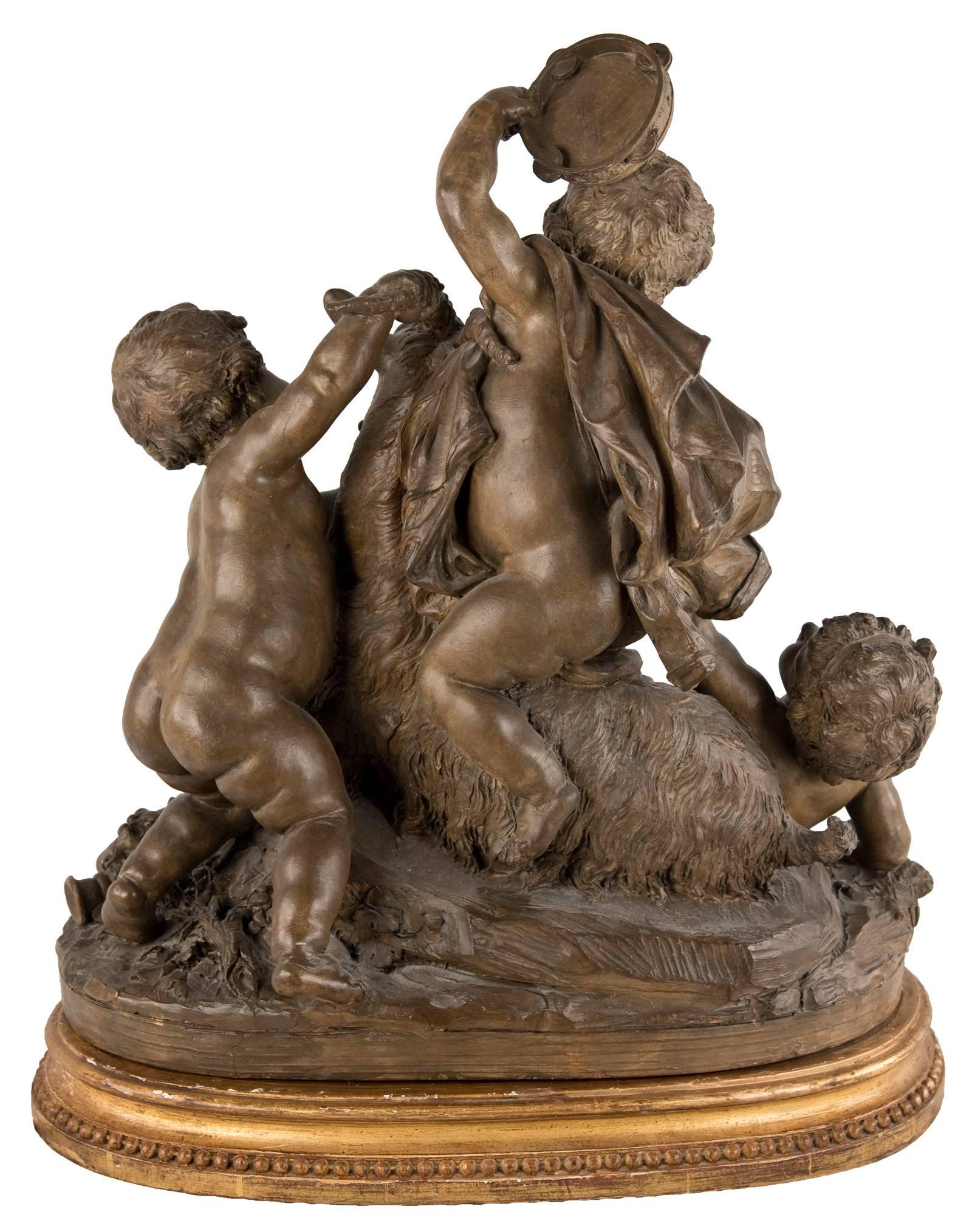 A patinated terra-cotta grouping of a horned goat surrounded by playful putti on a gilt wooden plinth with beaded edge detail. Captured in this piece is a sense of movement and enthusiastic energy as depicted through fruiting garlands, flowing