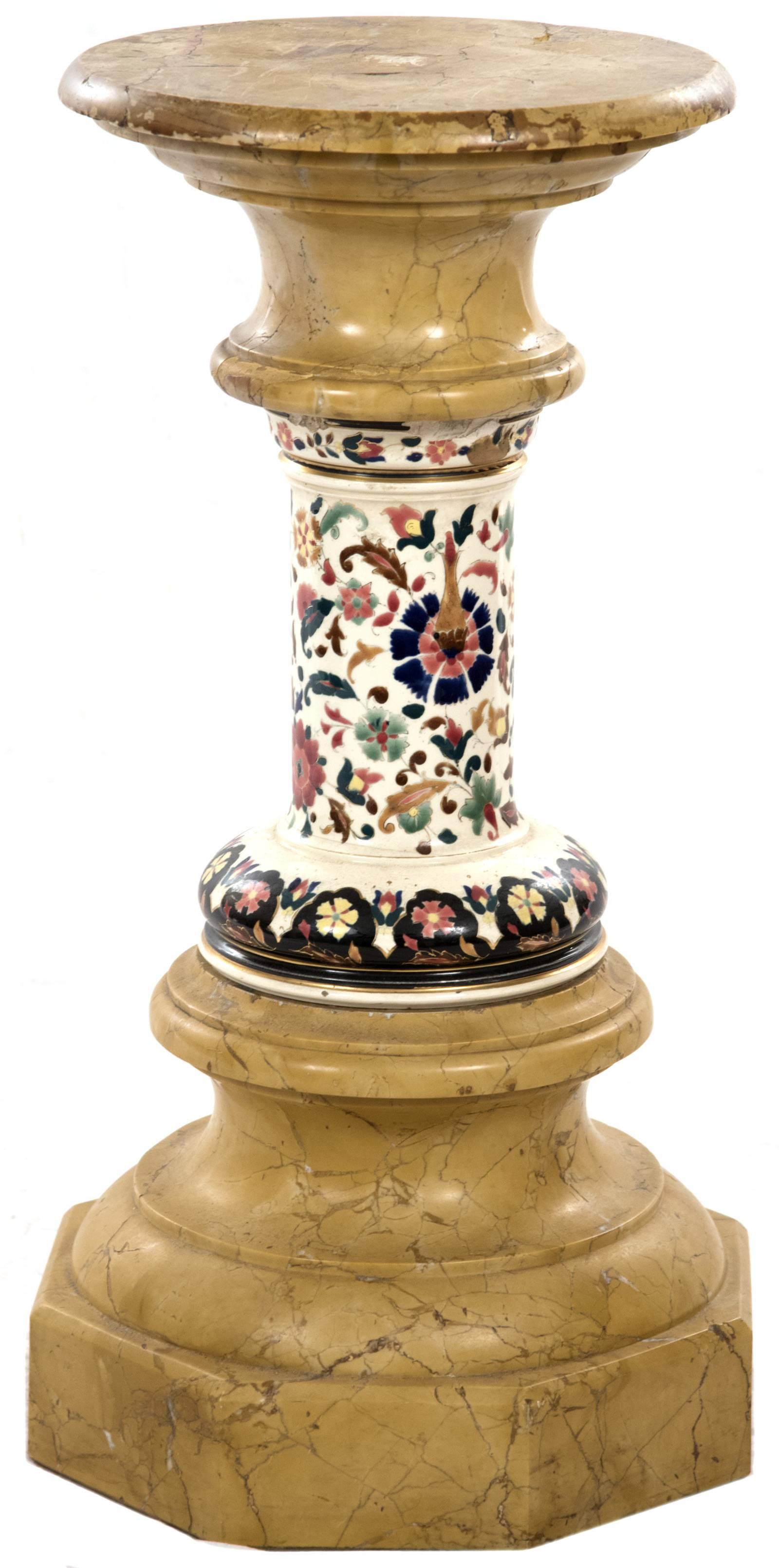 A pair of pedestals with round marble tops surmounting polychrome enamel scrolling floral and folate designs on a white ground, raised on a carved and stepped octagonal marble base.