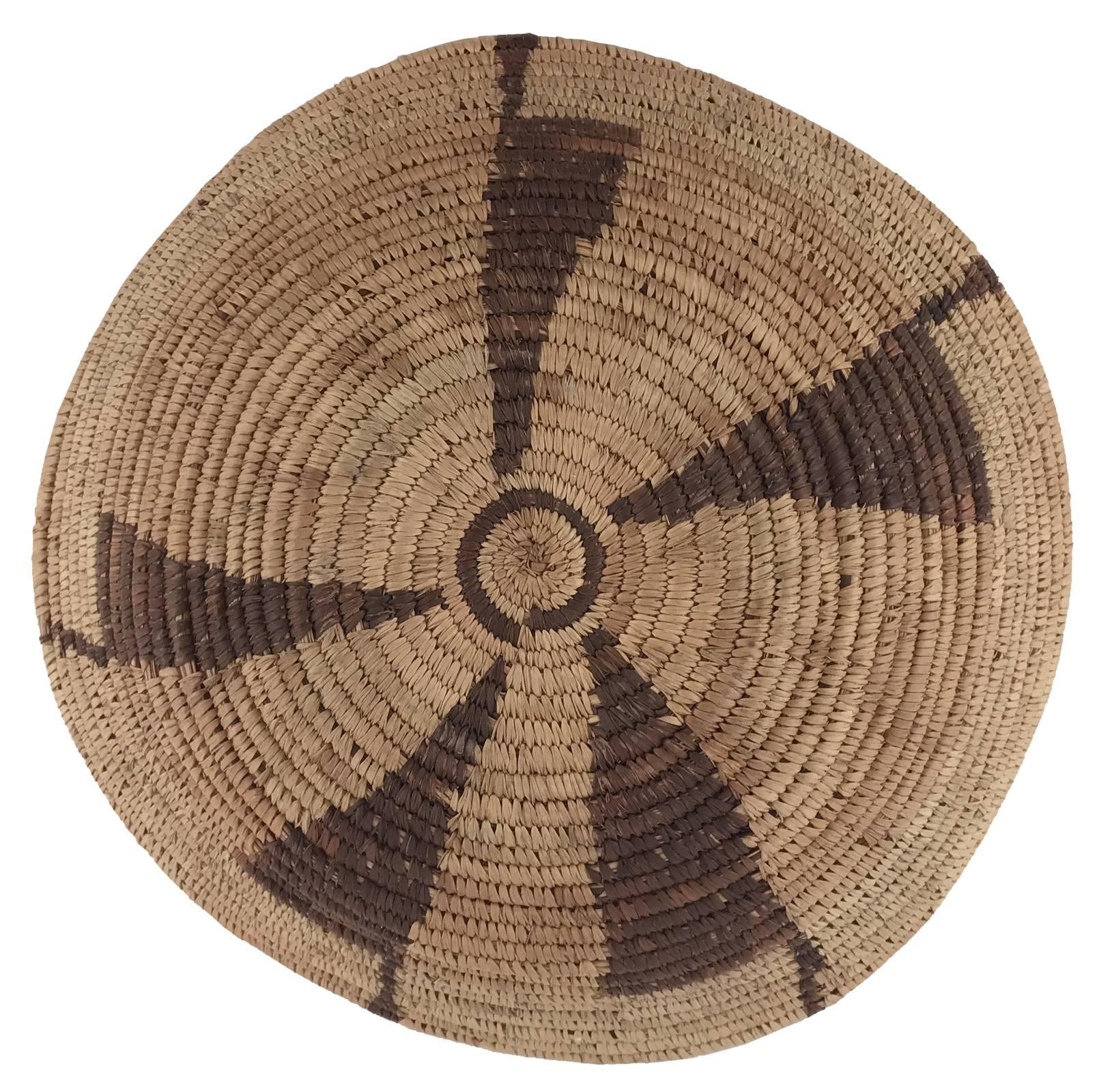 A Native American woven shallow bowl or tray decorated with contrasting triangular pattern.