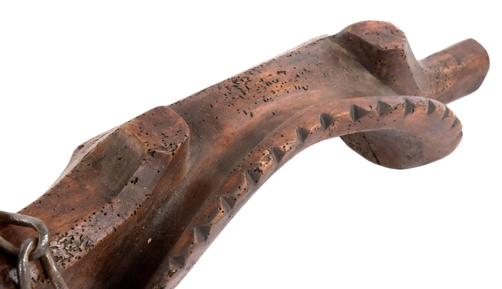 A 19th century French handmade walnut double cattle yoke shaped from a single piece of wood that was carved and fitted with iron and brass hardware.