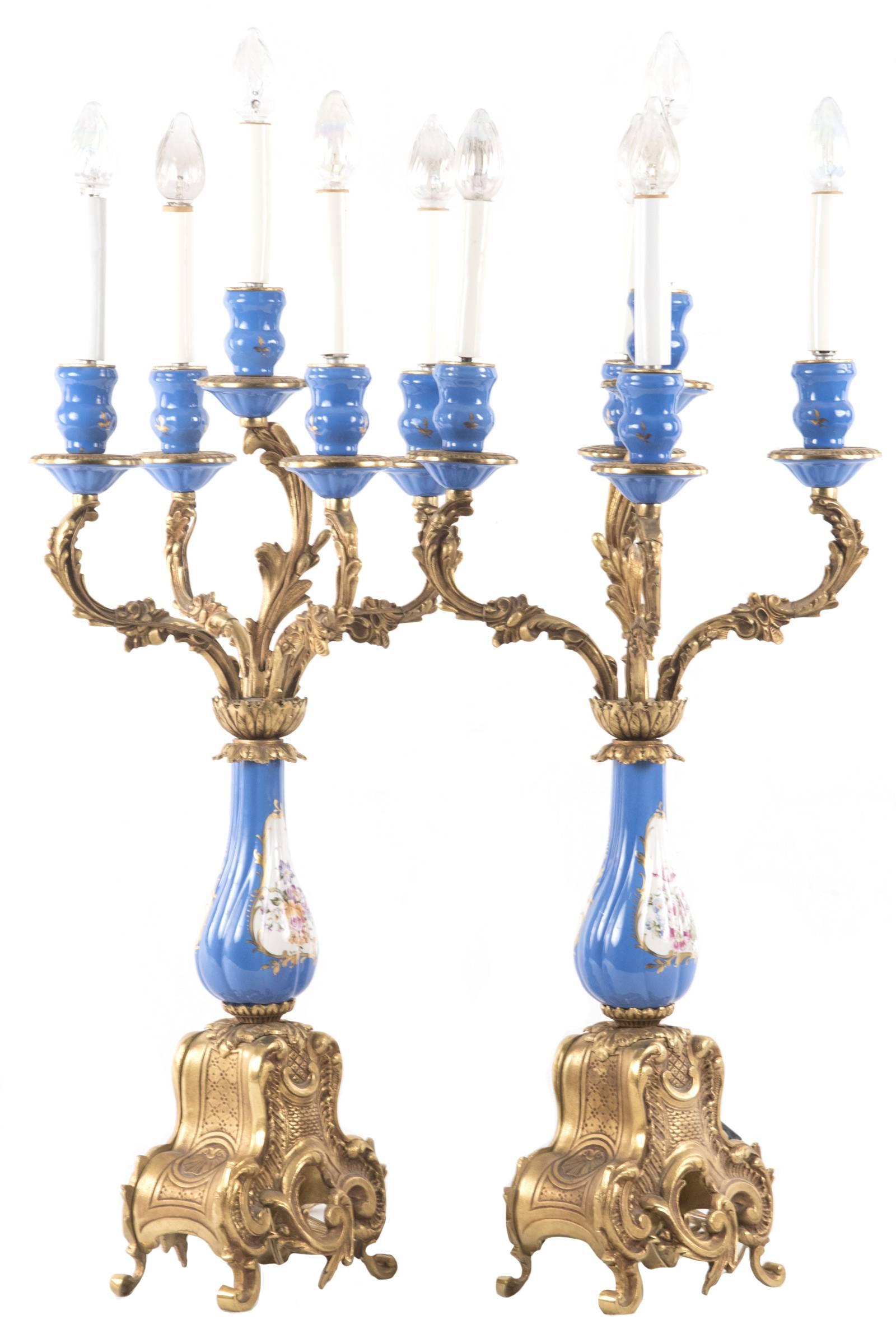 Light blue sevres style porcelain and ormolu-mounted five-light candelabra. The electrified candle-shaped lights are supported in shaped sconces, the tapering drip pans supported on scrolling filigree arms that meet at a stylized collar above a