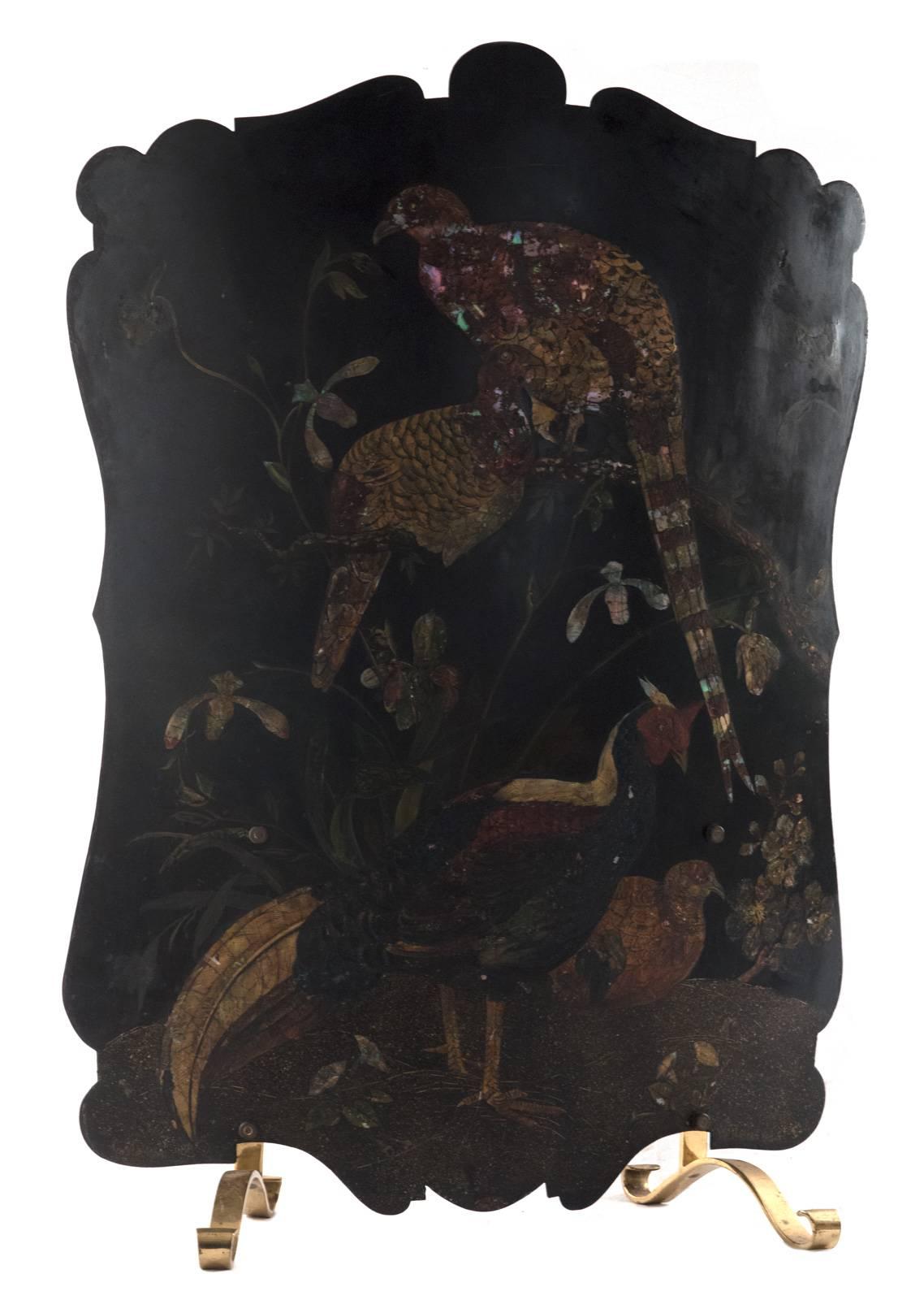 Painted and decorated with mother-of-pearl, this large screen depicts three exotic pheasants resting on a flowering tree. The curved metal screen rests on two S-scrolled brass feet.