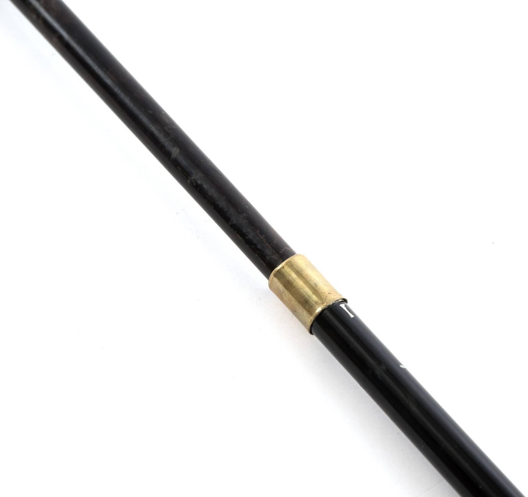 A turn of the century cane topped with an antler handle and sterling silver collar with raised engraving, and an ebonized, re-sizable sheath with a brass neck. Missing ferrule.