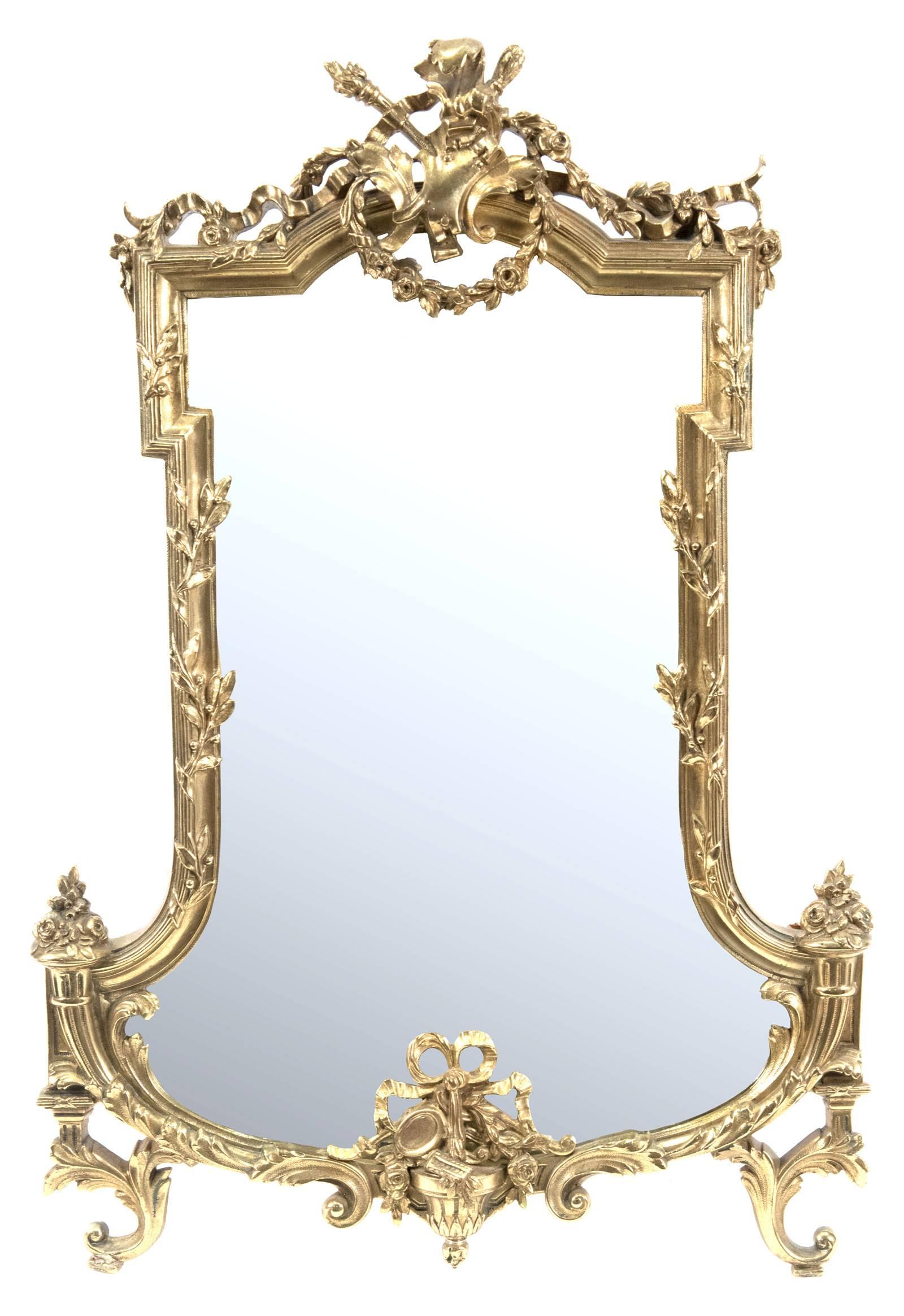 A large 18th century neoclassical shaped carved giltwood wall mirror crested with scrolling acanthus leaves, floral garlands and ribbon above borders twisted with foliate that flare at the bottom corners. Scrolling acanthus leaves and c-scrolls