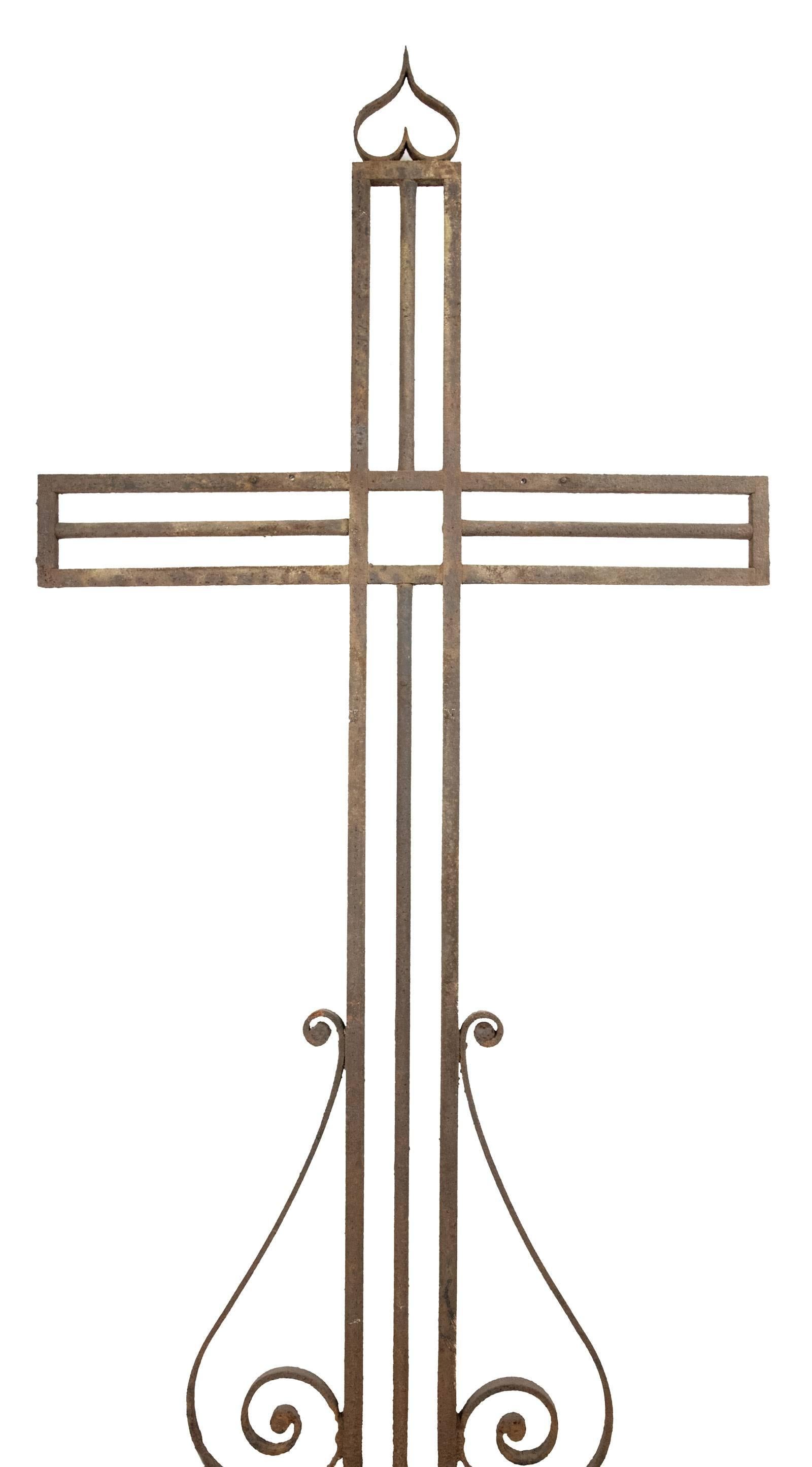 A late 19th century crucifix constructed in wrought iron in a simple geometric form, embedded in a stone pedestal.