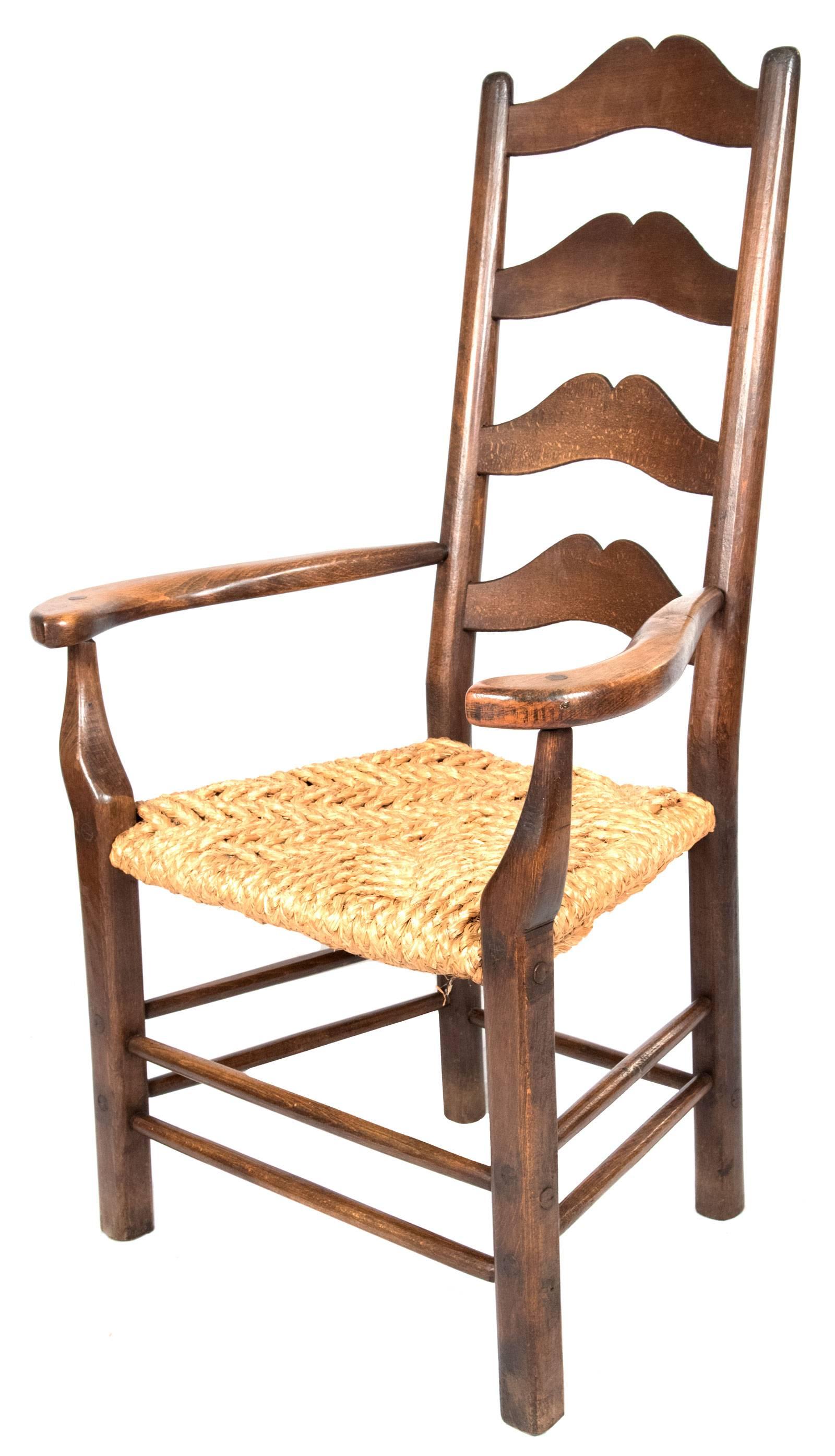 A set of provincial ashwood ladder back chairs with turned uprights connected by shaped splats above a rush seat, which is supported by simply turned legs and stretchers. The set includes nine chairs and one slightly oversized armchair.