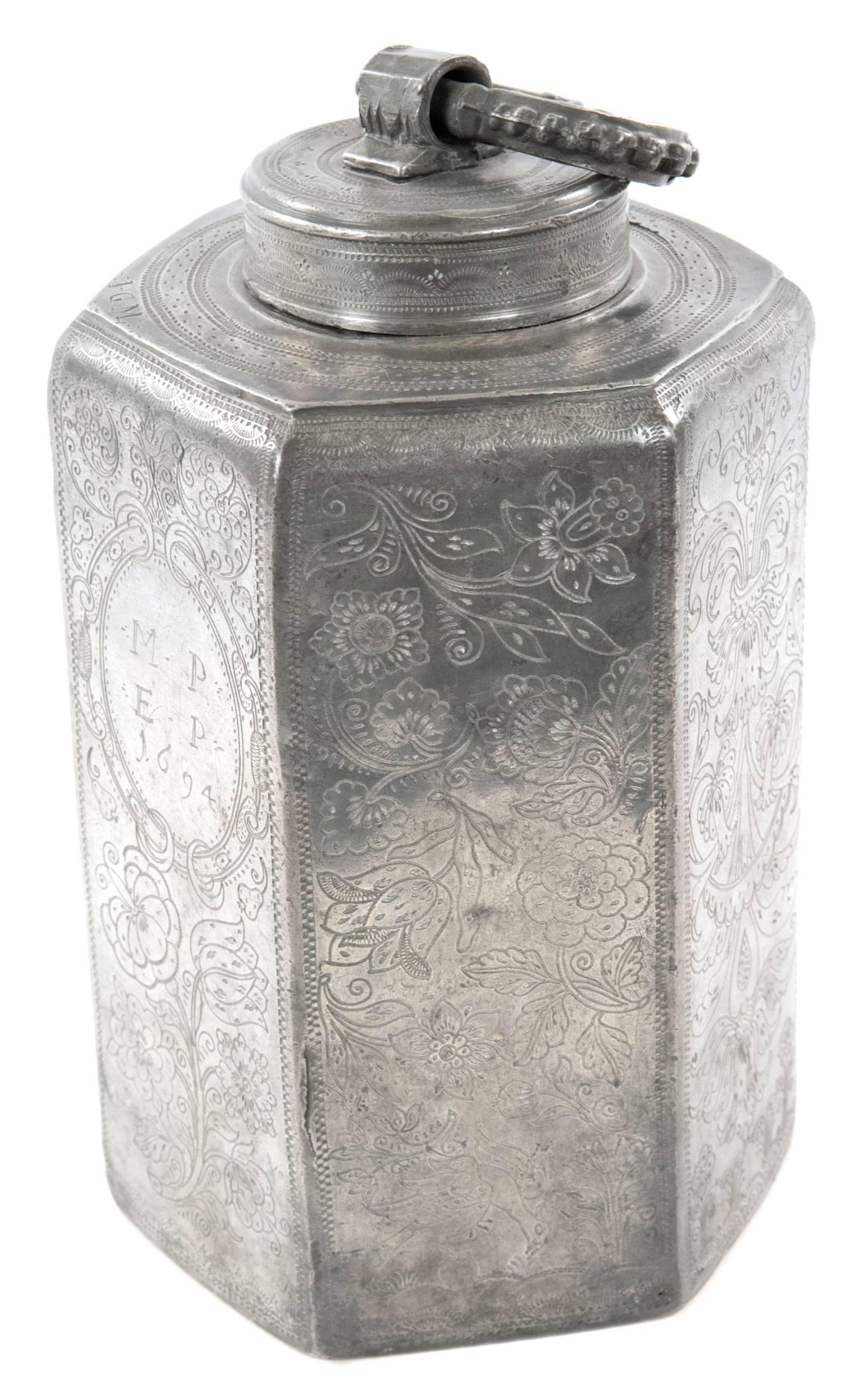 A German pewter canister in the form of a six-sided hexagon, each side beautifully decorated with very fine-lined engravings of floral groupings and meandering foliate work, which decorate four bordered panels, while the back panel includes a crown
