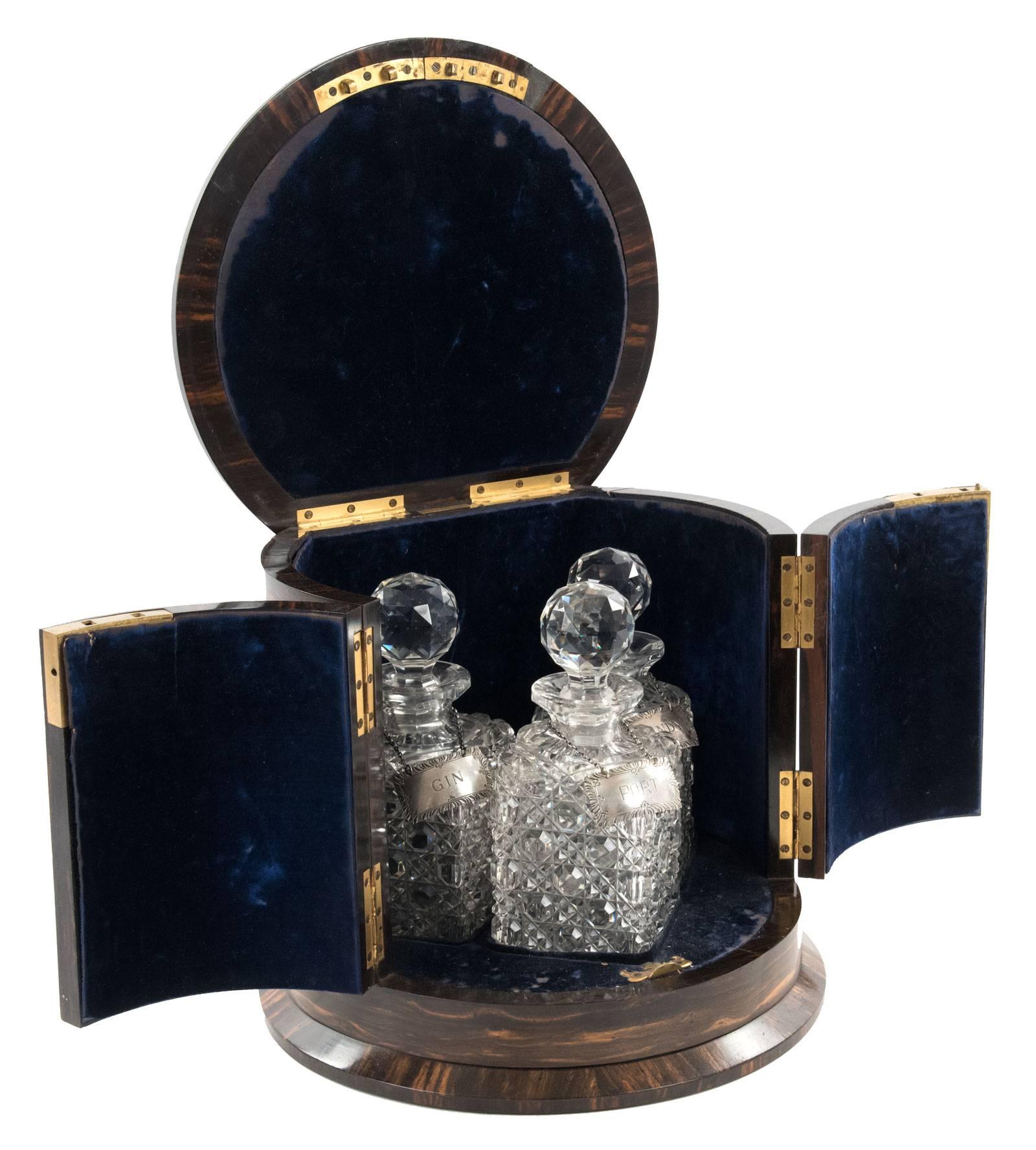 A mid-19th century coromandel bar with hinged lid and locking two-door cabinet front that opens to reveal an interior lined with blue felt, which houses a three-piece crystal decanter set sitting within fitted mouldings, with an engraved plaque