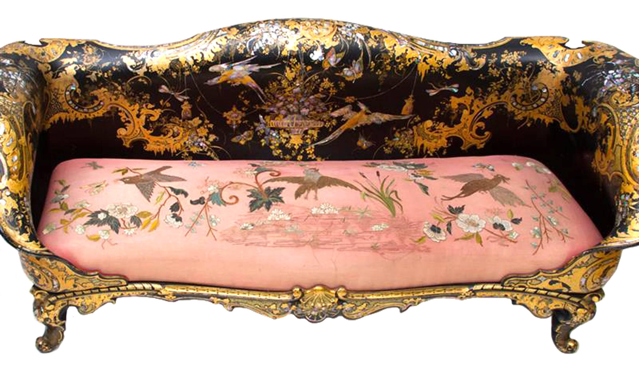 A mother-of-pearl and parcel-gilt inlaid papier mâché "japanned"settee decorated with floral sprays, urns and birds, surrounded by scrolling borders highlighted in gilt, on a conformingly decorated sea trail, with padded seat embroidered