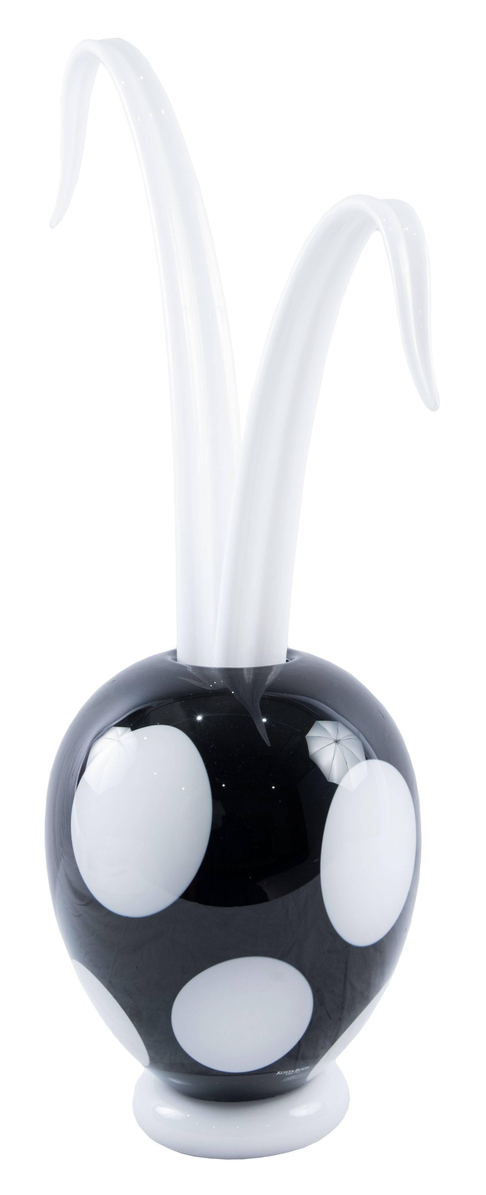 A beautiful Scandinavian glass vase from Kosta Boda by designer Kjell Engman. An ovoid black ground body decorated with large white dots with tall, organically shaped tendrils emerging from within the vase, all mounted on a white base. Engman