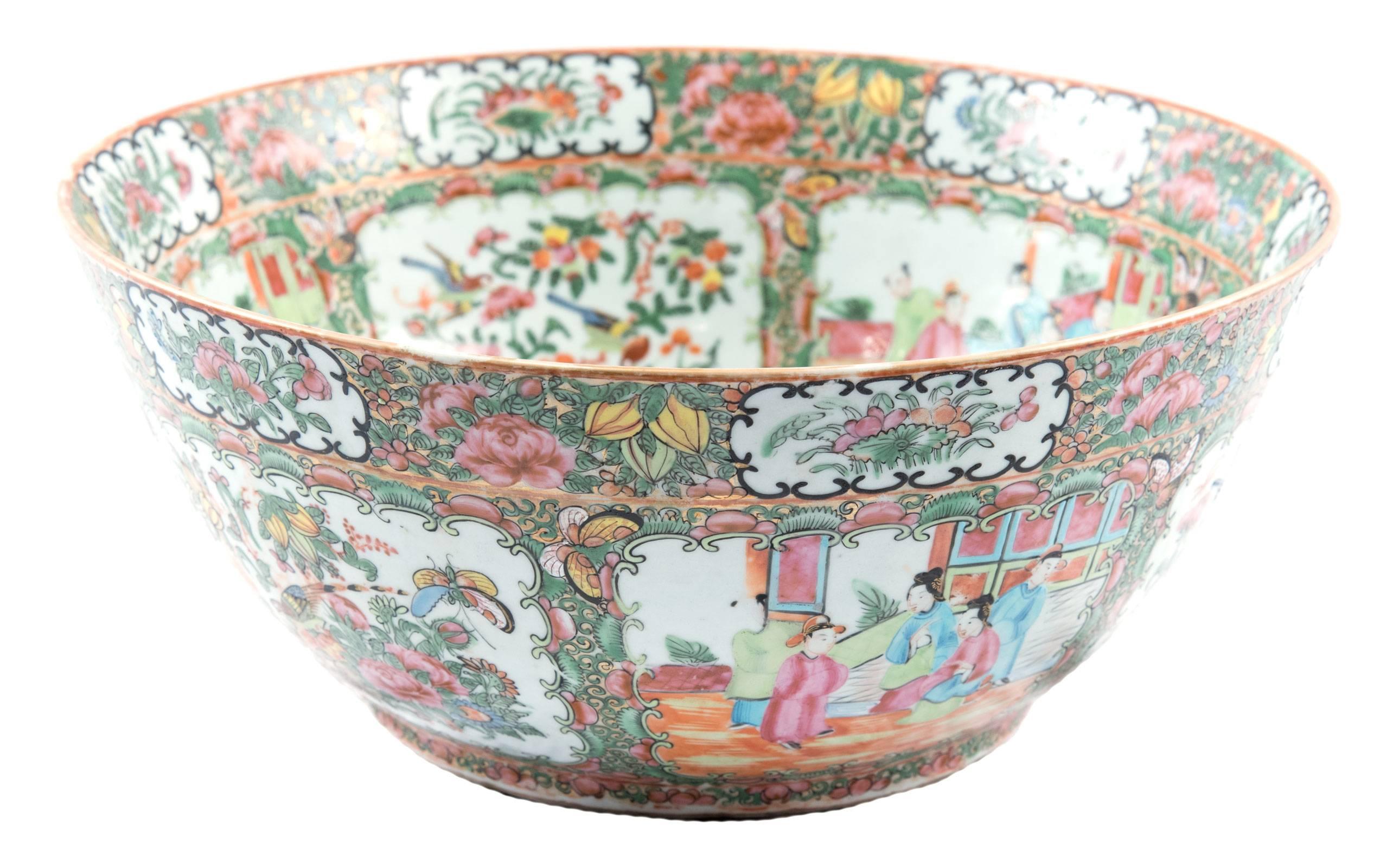 A finely decorated large famille rose medallion punch bowl with c-scroll cartouches containing alternating vignettes decorated with court scenes and bouquet of flowers with sacred bird patterns, on a field of vines populated by butterflies to a rim