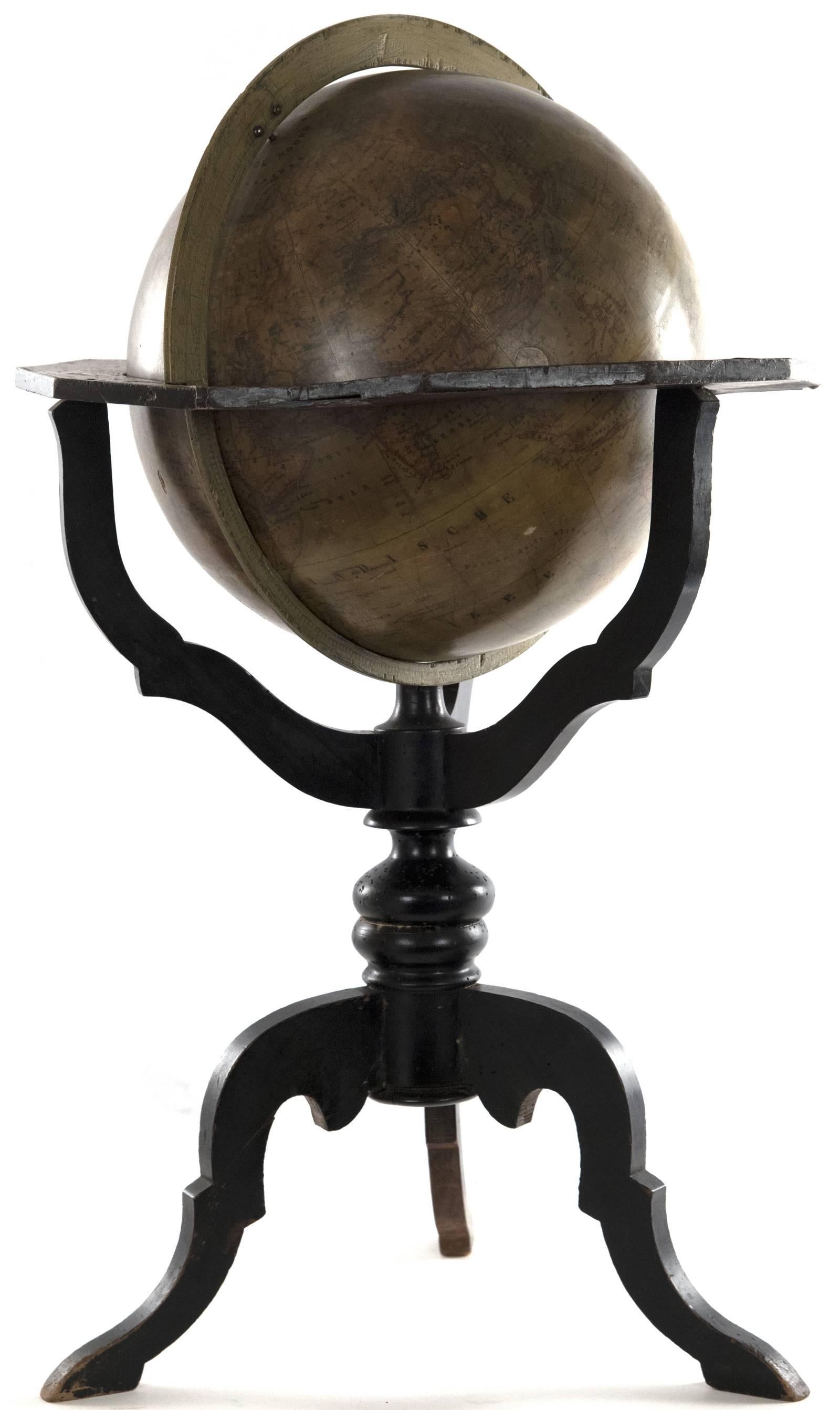 A late 19th century Netherlandish globe with a brass meridian ring and horizontal wooden ring with zodiac, month and compass directions, supported within a wooden turned Stand with tripod base. The globe is papier mâché and annotated in Dutch.