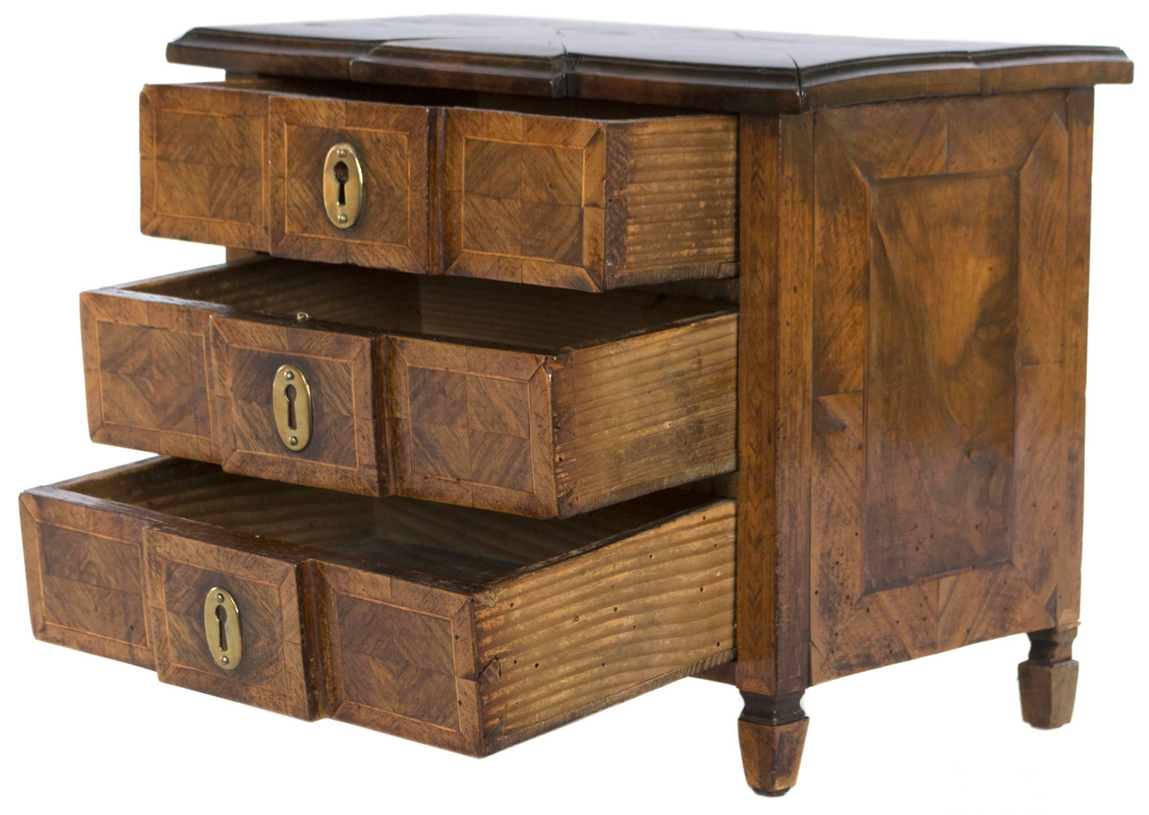 Covered in luxurious burl walnut, and amaranth, period Louis-Philippe jewelry box in the form of a three-drawer commode.