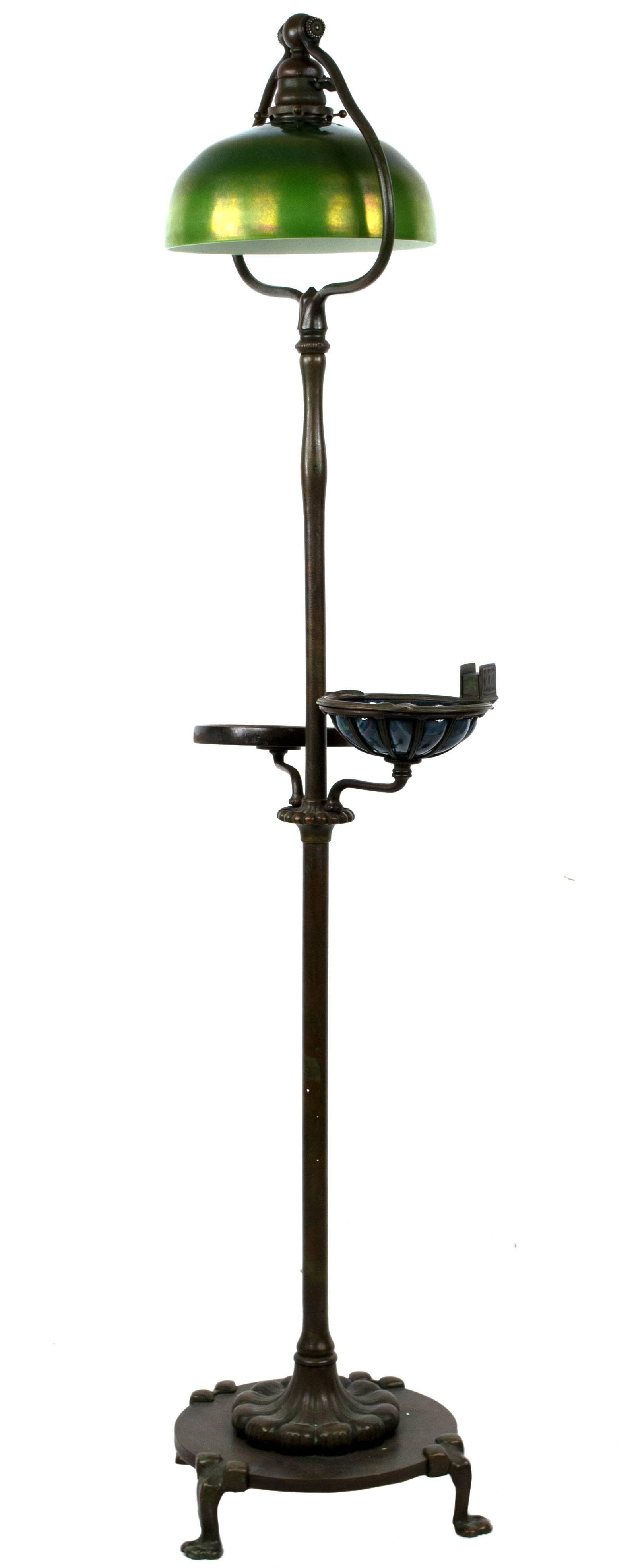 A very fine Tiffany Studios bronze floor lamp with green Favrile shade and two arms, one of bronze with a wood platform and the other made of bronze with iridescent favrile glass bowl.