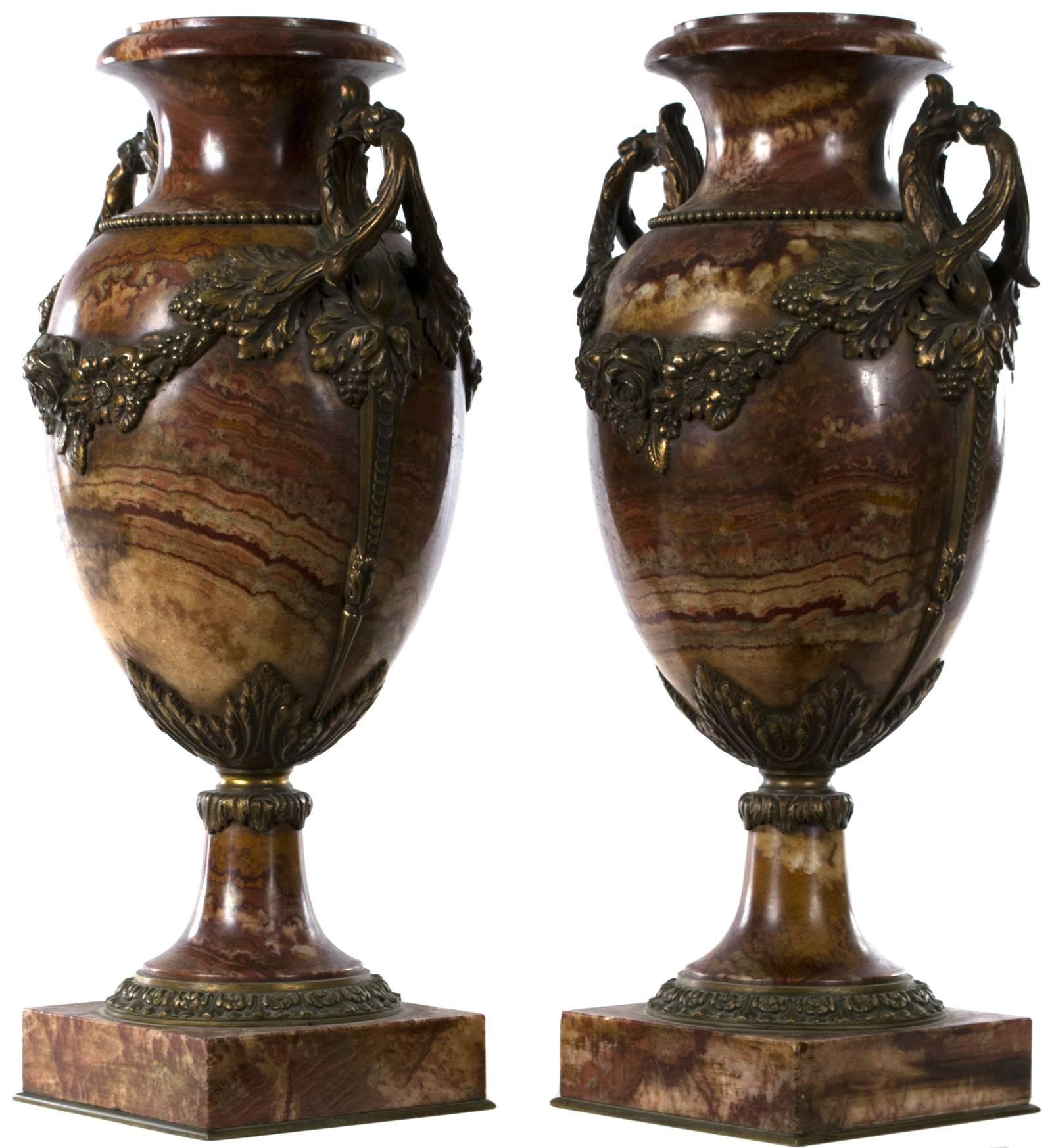 Two richly colored marble urns with elaborate hand-chased and gilt bronze appliqué handles and wreaths, made in France and dating to the third quarter of the nineteenth century.