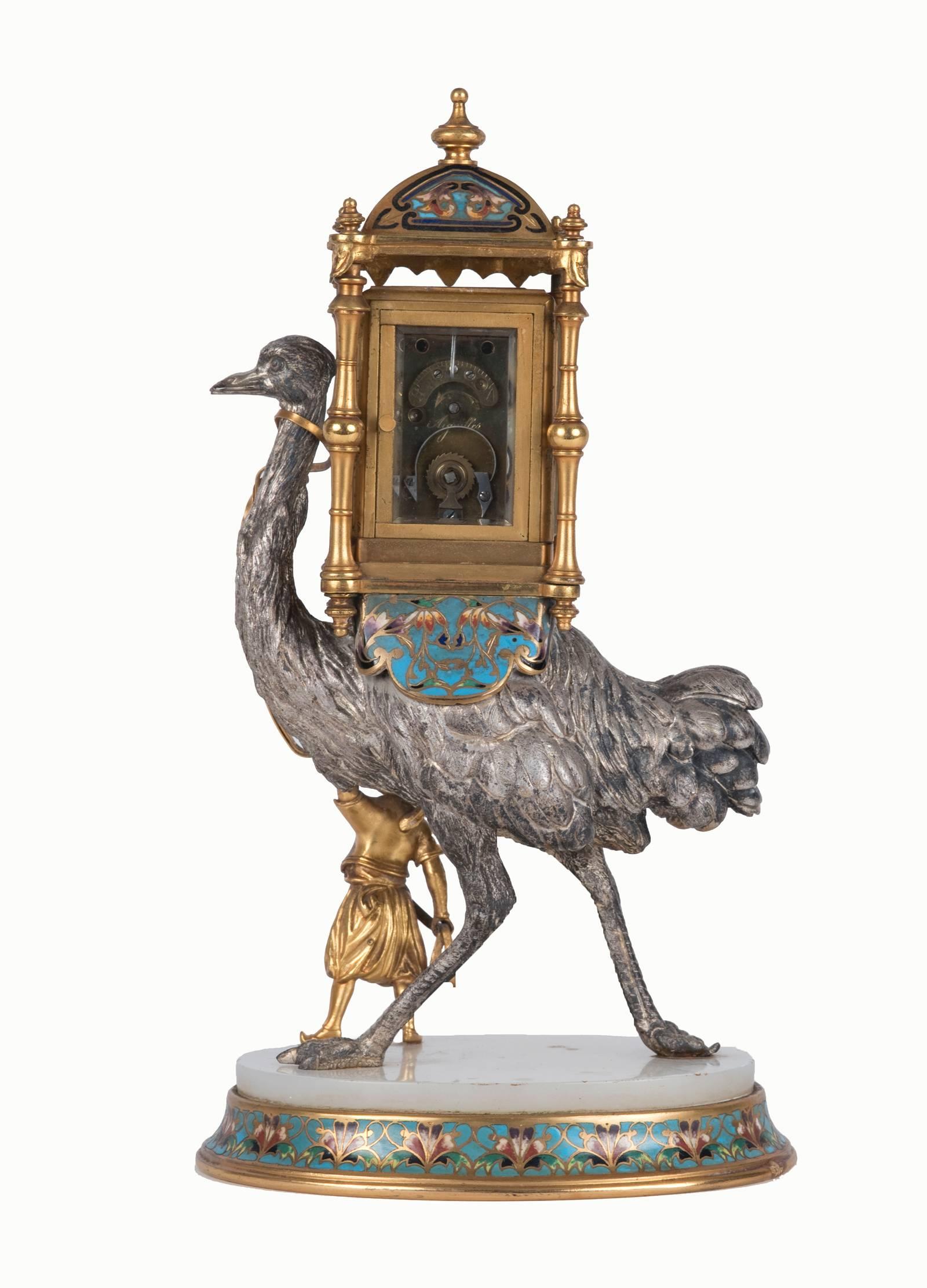 On an onyx and finely detailed cloisonné base, a Turkish man leads an oversized ostrich with an encased clock on its back. Through the beveled glass panels of the case, the clock face depicts the name of the Parisian manufacturer of this sculptural