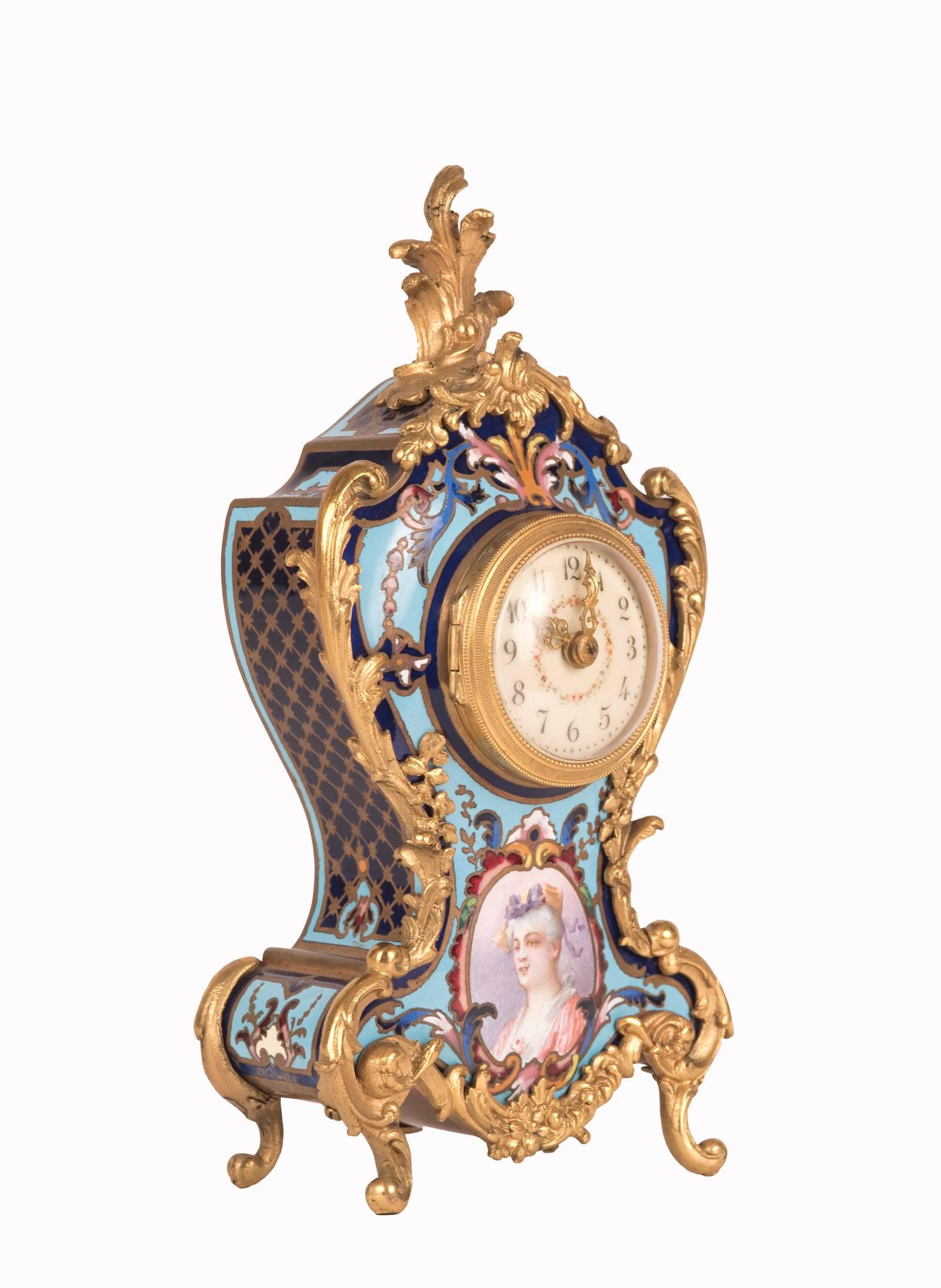 The cartouche form case of brightly colored enamel and circular dial is enhanced with elaborate gilt bronze ormolu with a foliate form finial and sits on C-scroll feet. The case is further decorated with the pastel portrait of a woman.
 