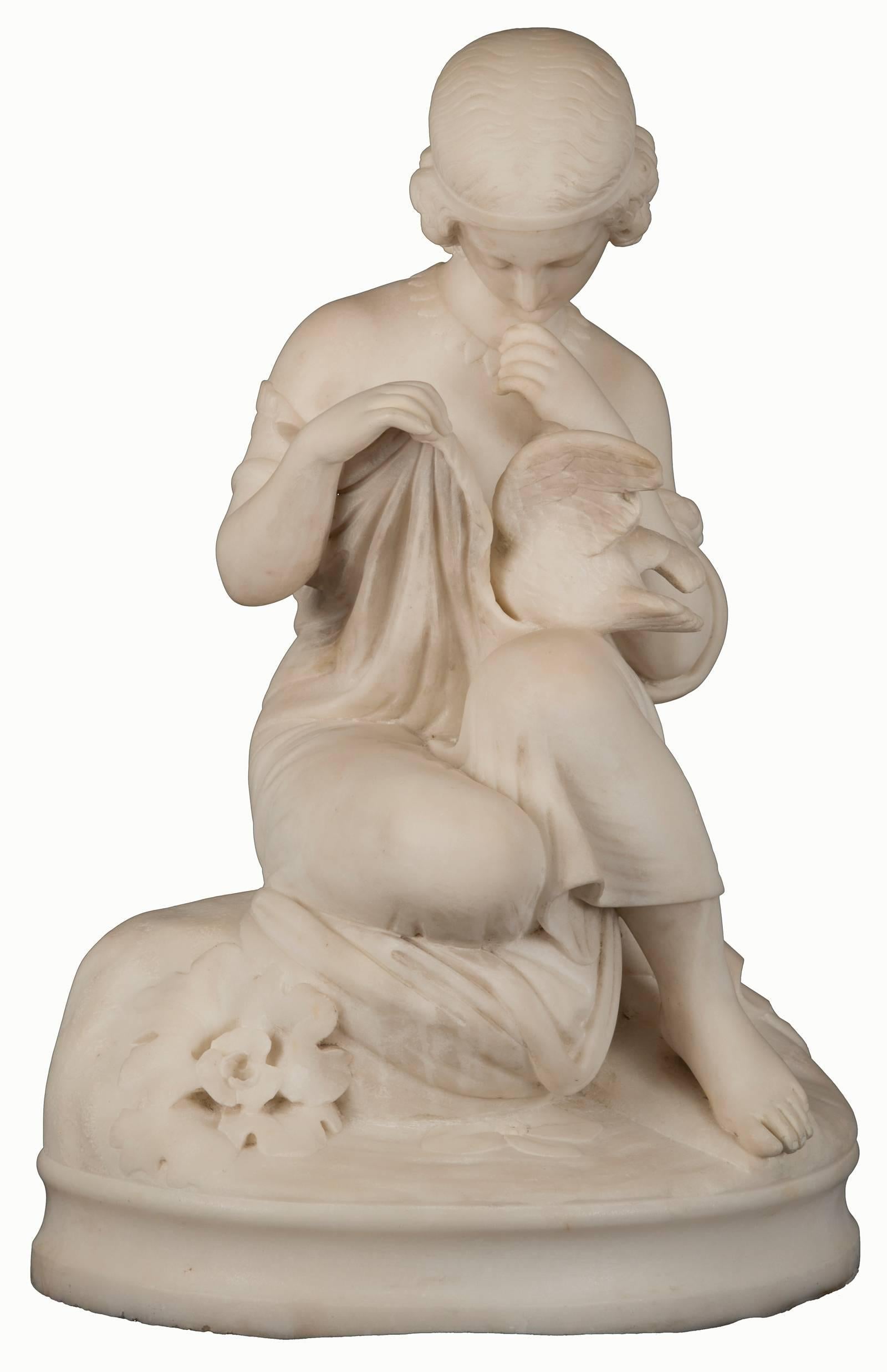 This figurative sculpture depicts a quiet moment when a young maiden gently enfolds a dove within the delicate cloth of her dress. The finely detailed carvings and beautifully rendered drapery are representative of the Italianate tradition. The