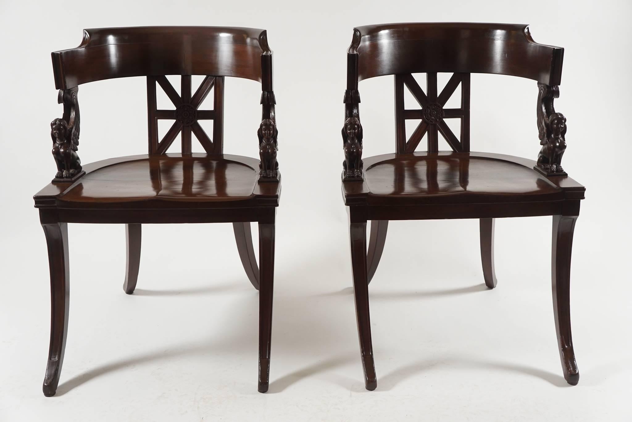 Extremely elegant pair of French, circa 1890, neoclassical style klismos form chairs of solid mahogany construction having deeply bowed continuous crest-rails supported by geometric pierced back-splats with central carved rosettes and carved female