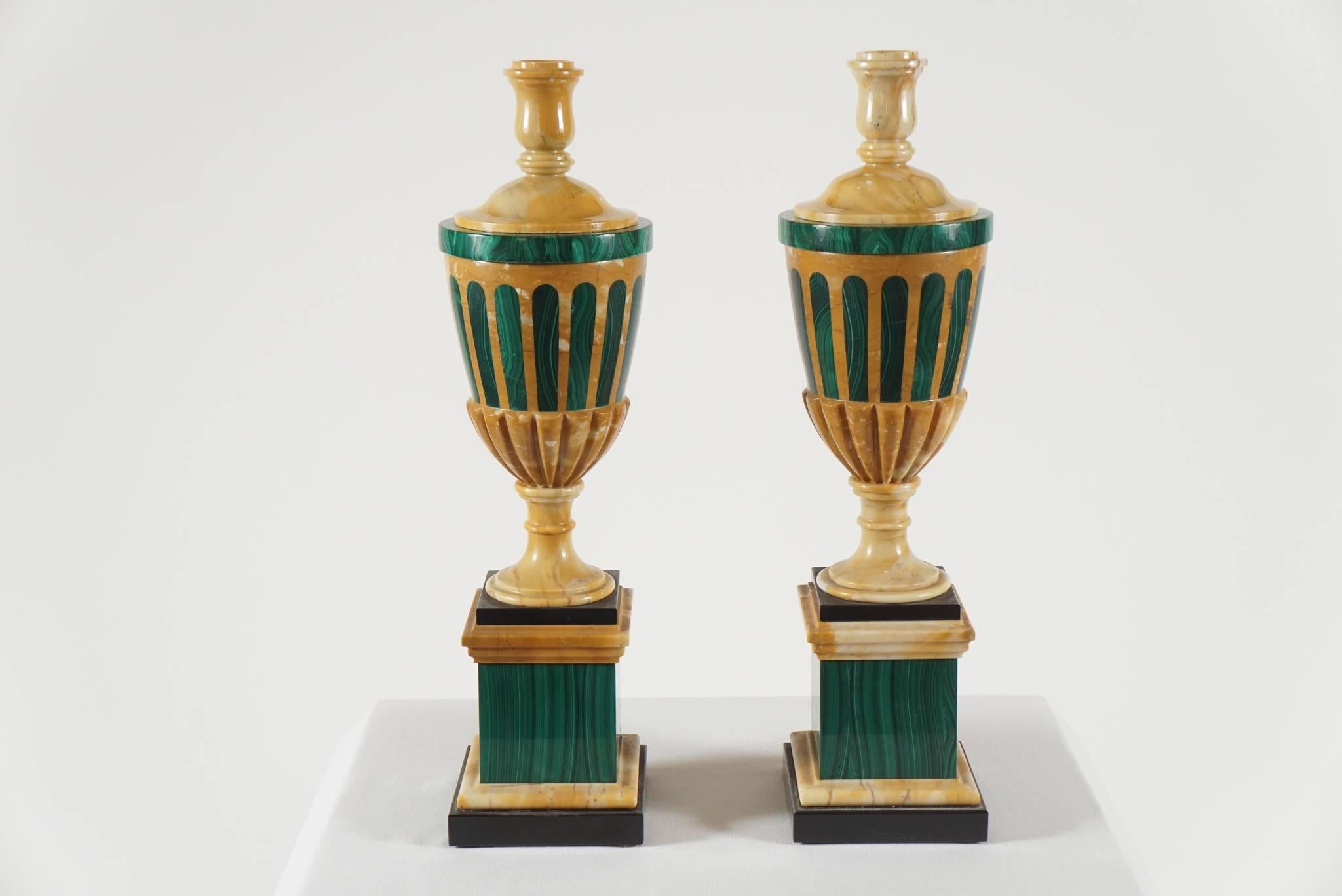 An elegant, circa 1900 pair of inlaid stone cassolettes of Adamesque urn form having reversible tops, with one side single candle cup, and the other finial side when not in use, on malachite inlaid giallo antico bodies on stepped malachite, giallo