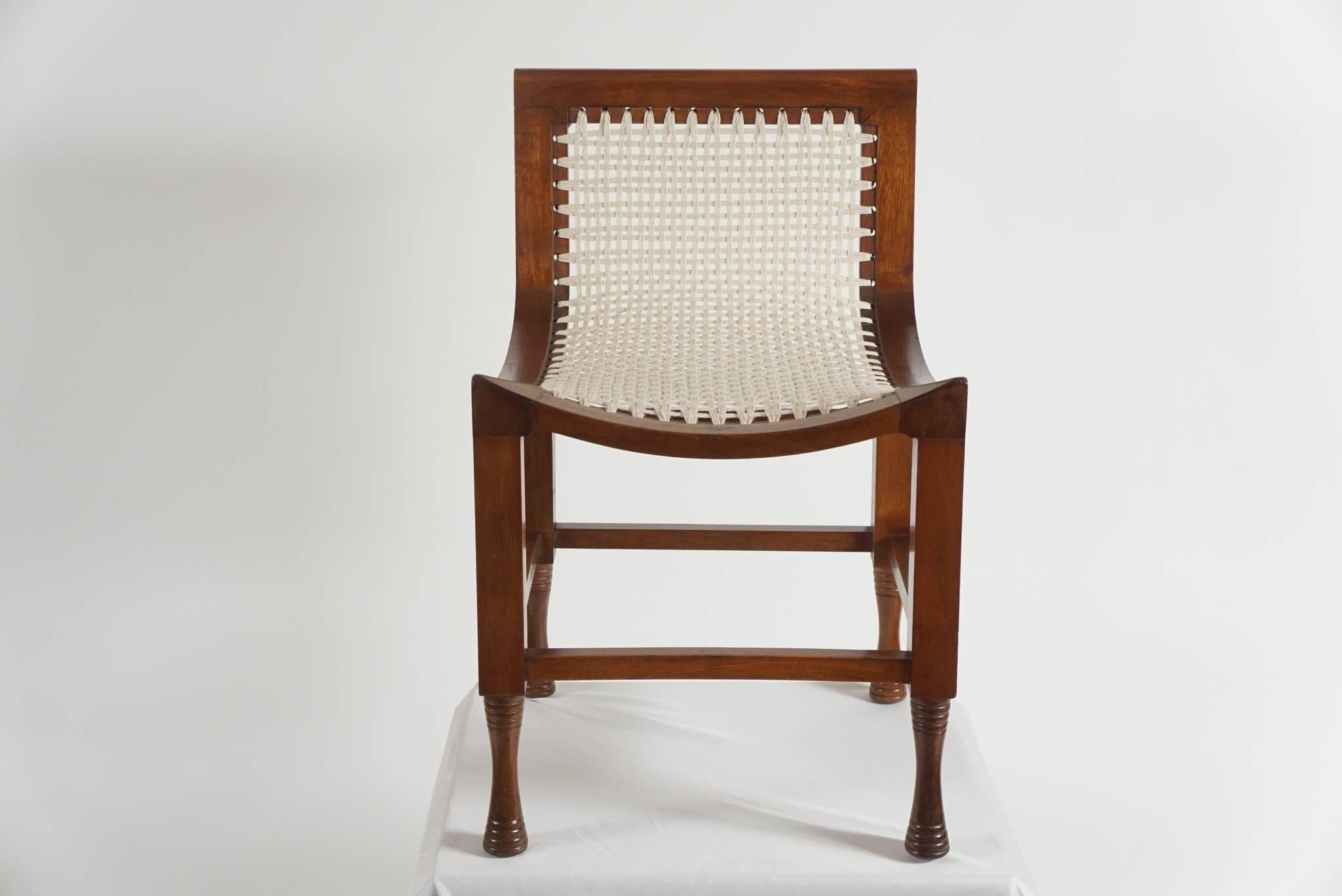 Wonderful, early 20th century, Liberty & Co. 'Thebes' Egyptian style child's chair or low-backed stool having carved mahogany frame with woven hemp twine seat.