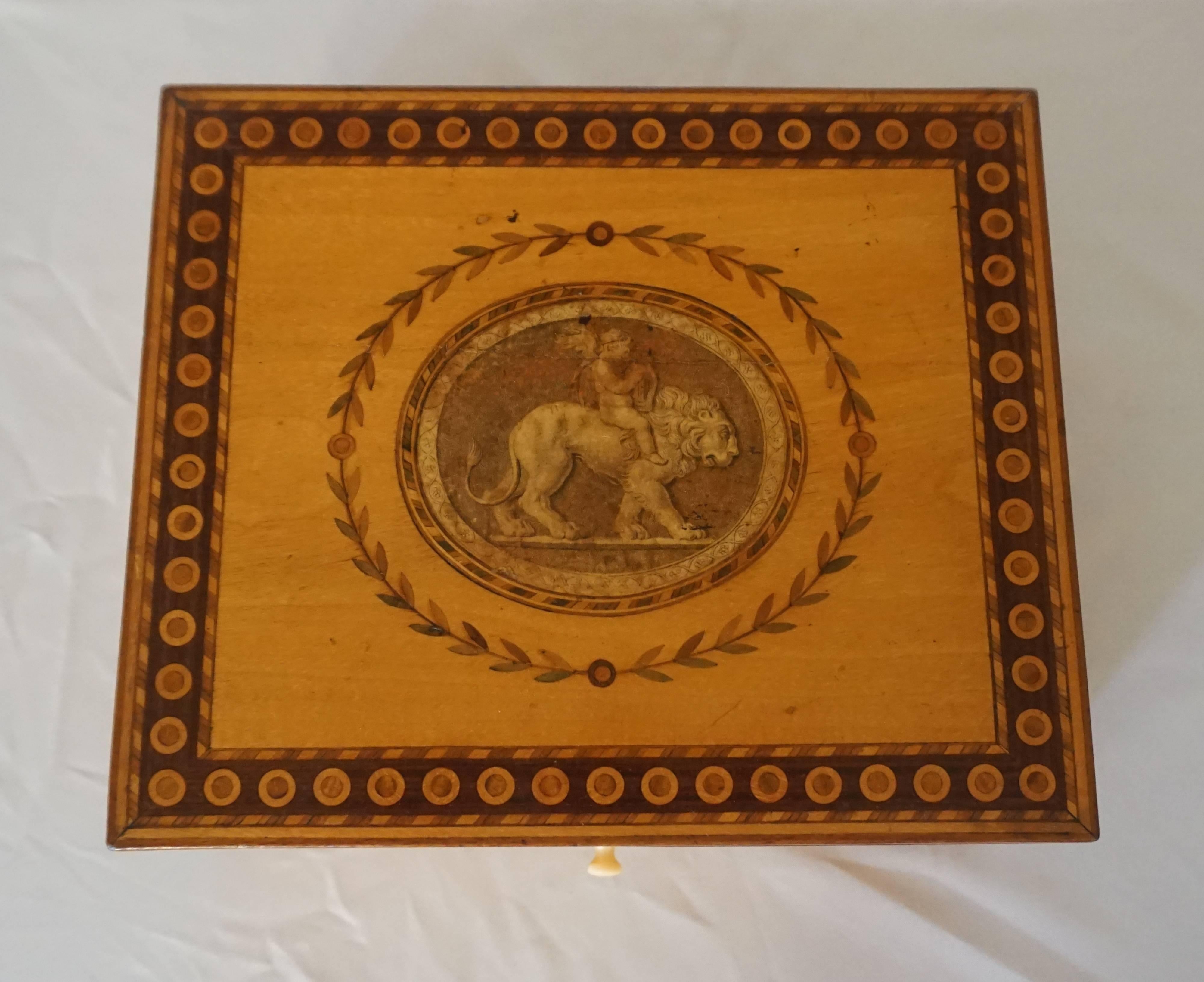 Fine English, George III period, circa 1785, letter or dresser box of rectangular form and satinwood case with hinged top having geometric inlaid mixed woods border surrounding central decoupaged engraved paper print of a putto with harp riding on