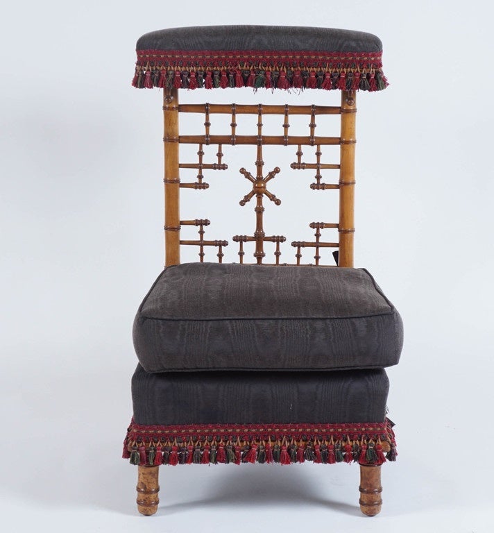 A wonderful French Napoleon III period voyeuse having upholstered fringed crest-rail surmounting back with intricately turned faux bamboo Chinoiserie trellis design, loose tie-back top cushion and upholstered fringed seat on turned legs. Flawless,