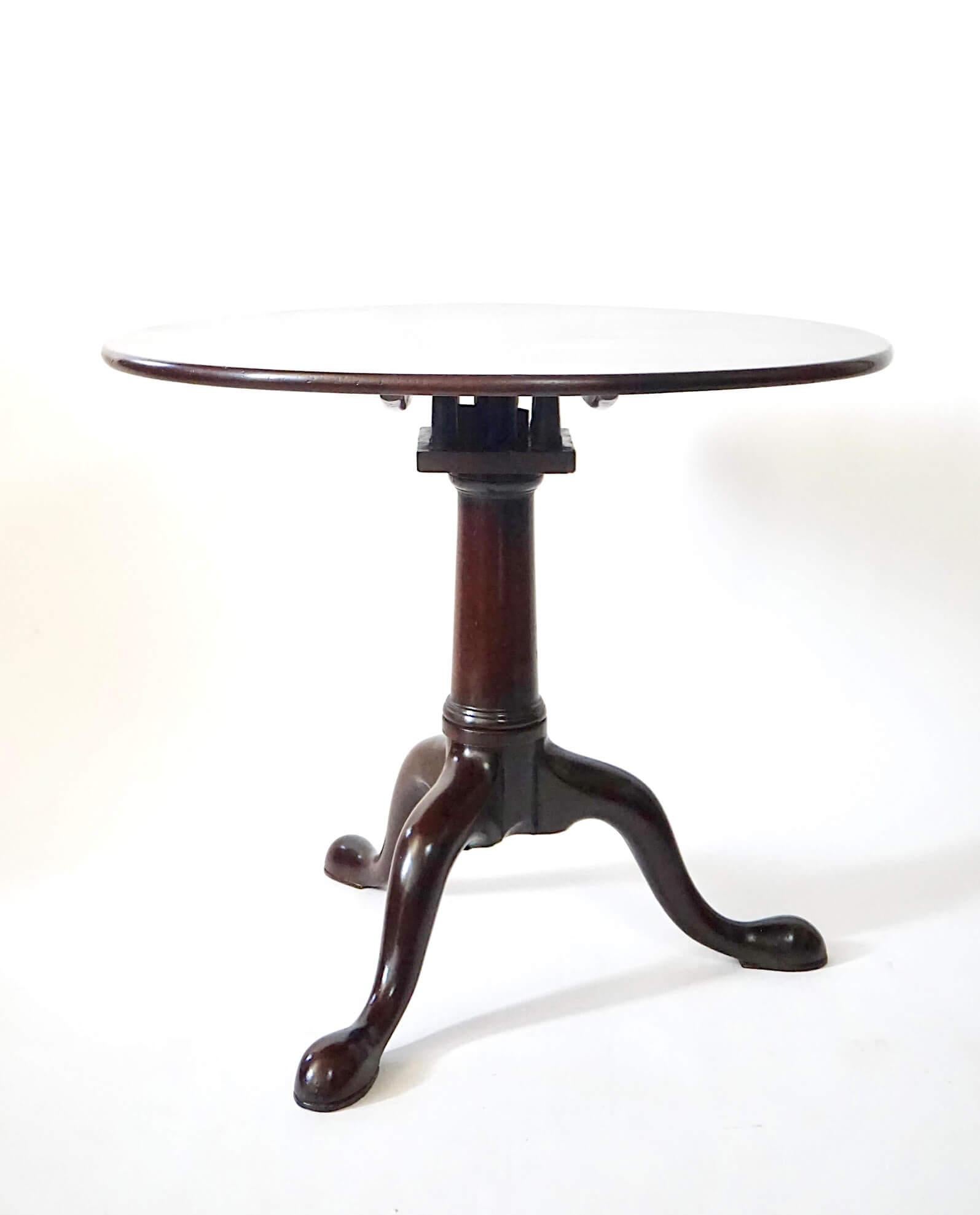 A fine circa 1740 English George II period 'pillar and claw' or tripod table of robustly drawn form and solid mahogany construction, the circular single-board top revolving on 'bird-cage' hinge (a square box-form hinge developed in the early