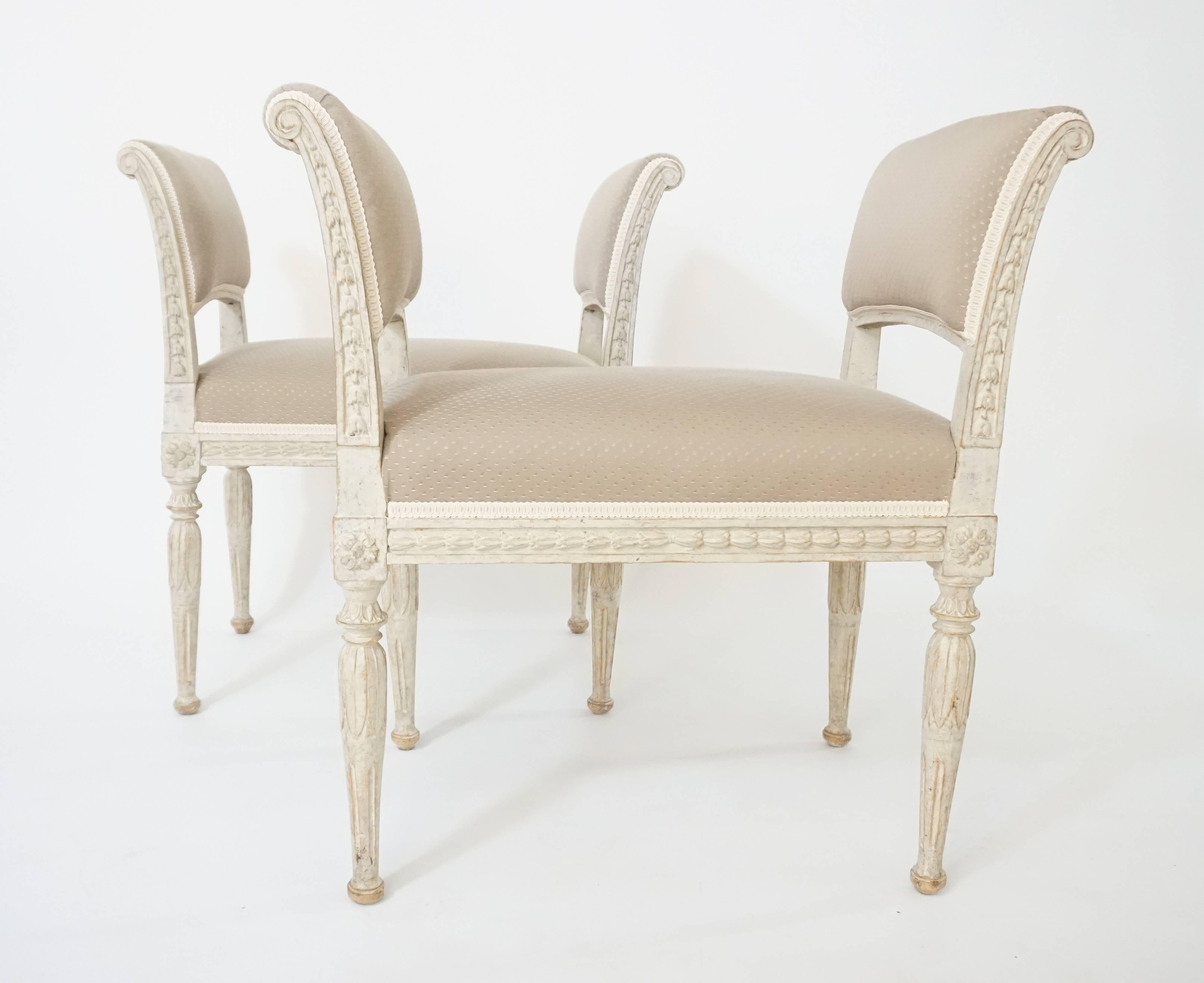 An elegant and rare pair of circa 1790 Swedish Gustavian period and style neoclassical benches in original paint, possibly by Royal Court chair-maker Ephraim Stahl, of rectangular form having outward scrolling upholstered sides with stiles having