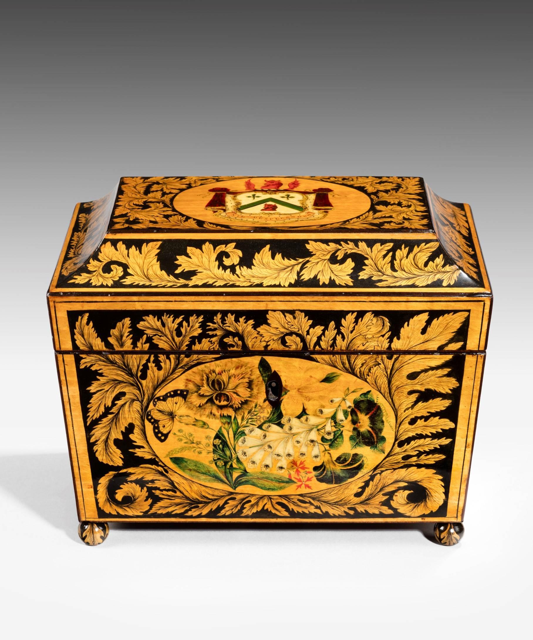 A superb Regency period penwork tea caddy of sarcophagus form; the tea caddy's lid decorated with a coat of arms and the sides with butterflies and flowers including lilies, foxgloves and roses surrounded by scrolling acanthus leaves; the tea