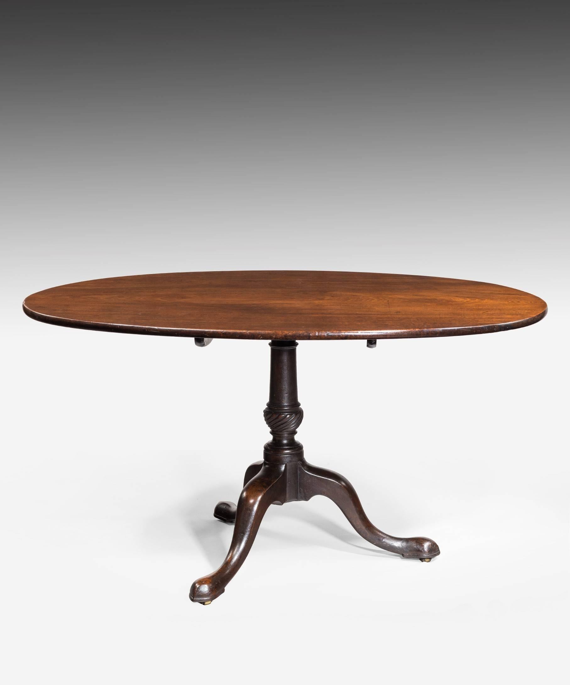 A large George II period mahogany oval supper centre table; the table's well figured tilt-top above a wrythen turned stem and raised on handsome cabriole legs terminating in pad feet.

This Georgian table is the ideal size for a supper table to