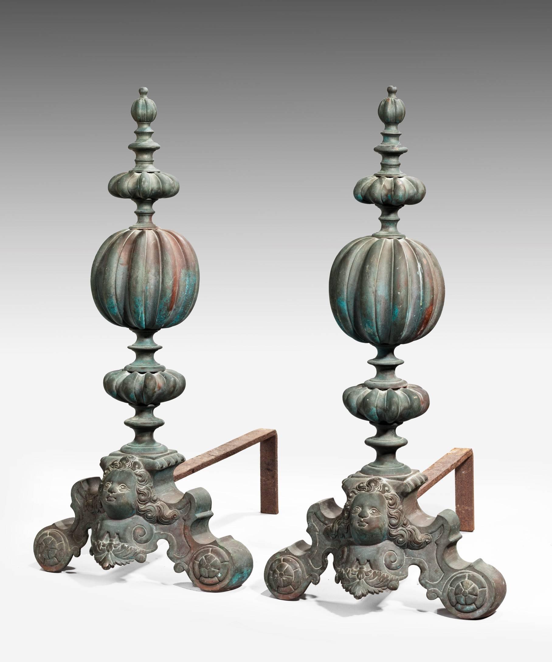 An impressive pair of Baroque style brass fire dogs; with knopped finials and scrolling feet with lovely verdigris patination. Similar fire dogs or andirons can be found in some of England's finest country houses including Knole, Kent.