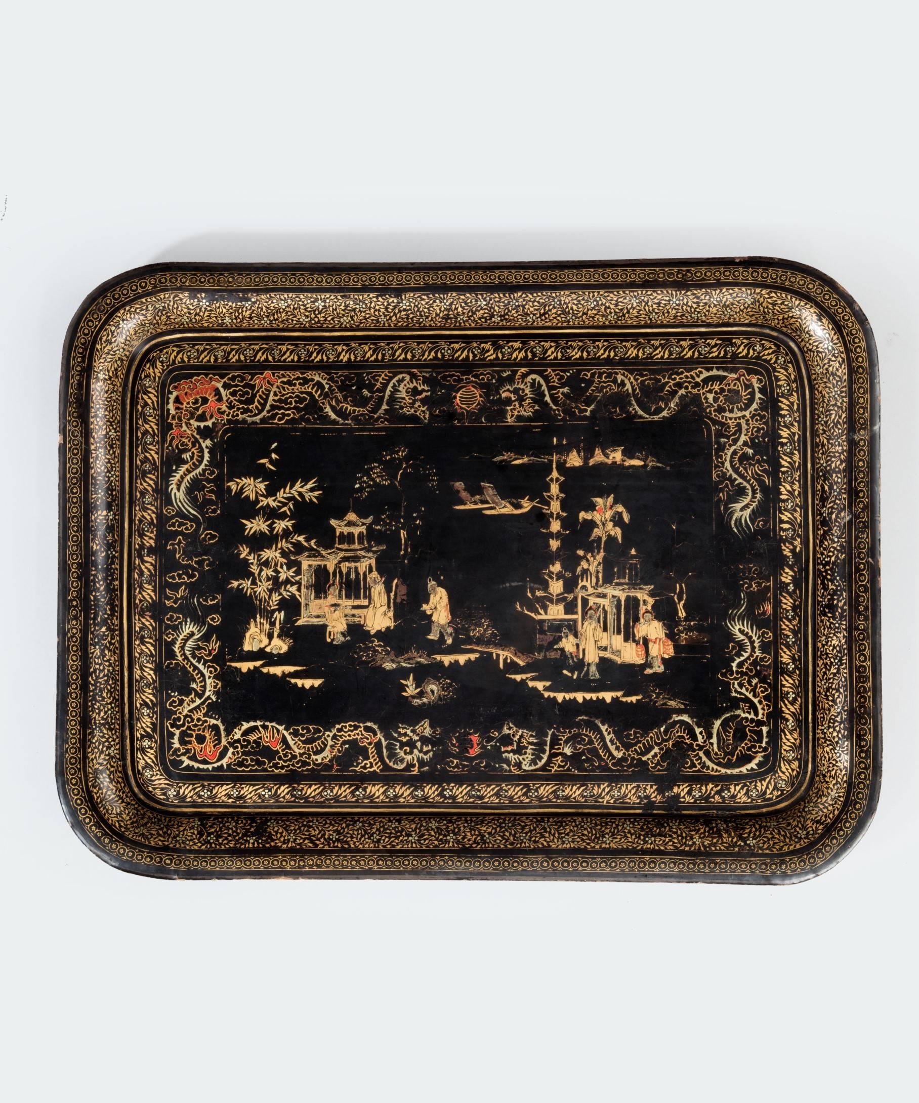 A rare set of three early 19th century Chinese Export lacquerware trays; each having a central scene of a Chinese landscape with figures and then decorated with borders of dragons and foliage all in gilt on a black ground. It is exceptionally rare
