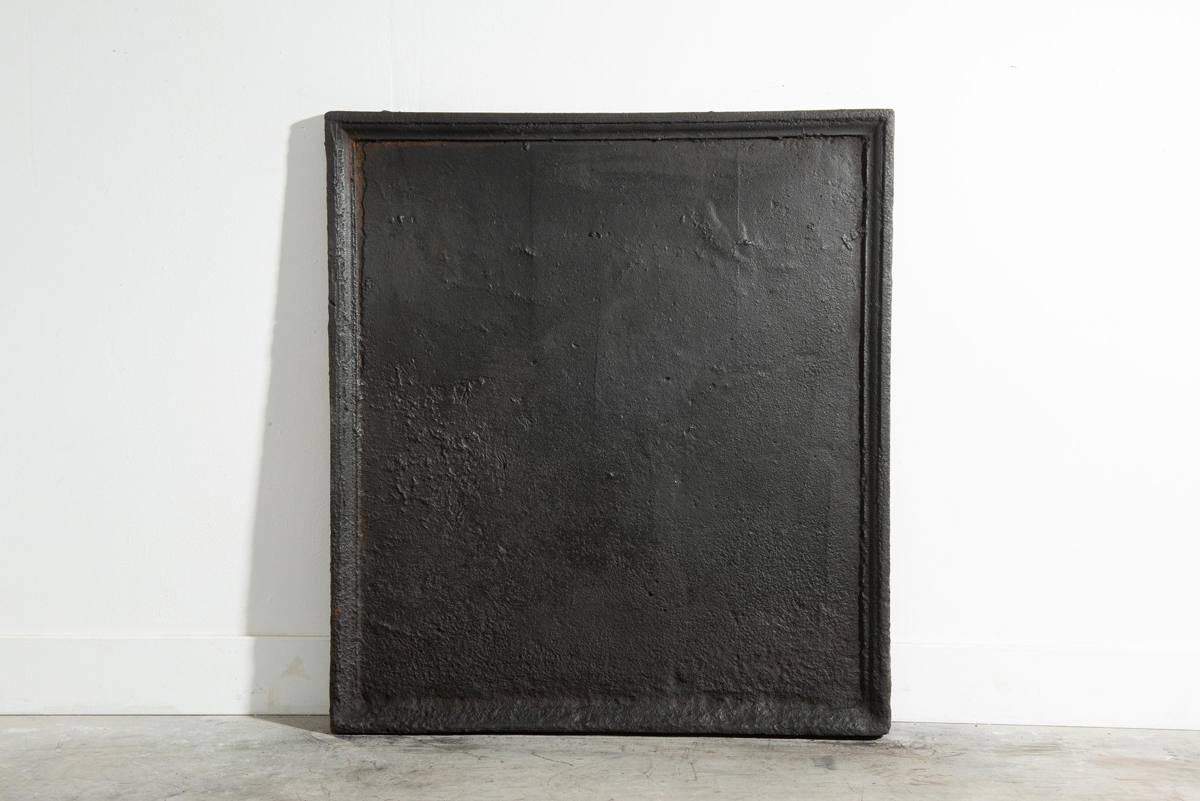 A beautifully crafted cast iron fireback, ideal for use as a functional fireplace insert or as a striking backsplash above a modern cooktop. 
Dating from the late 18t C. this piece feature rich profiled edges with a plain center. It possesses a