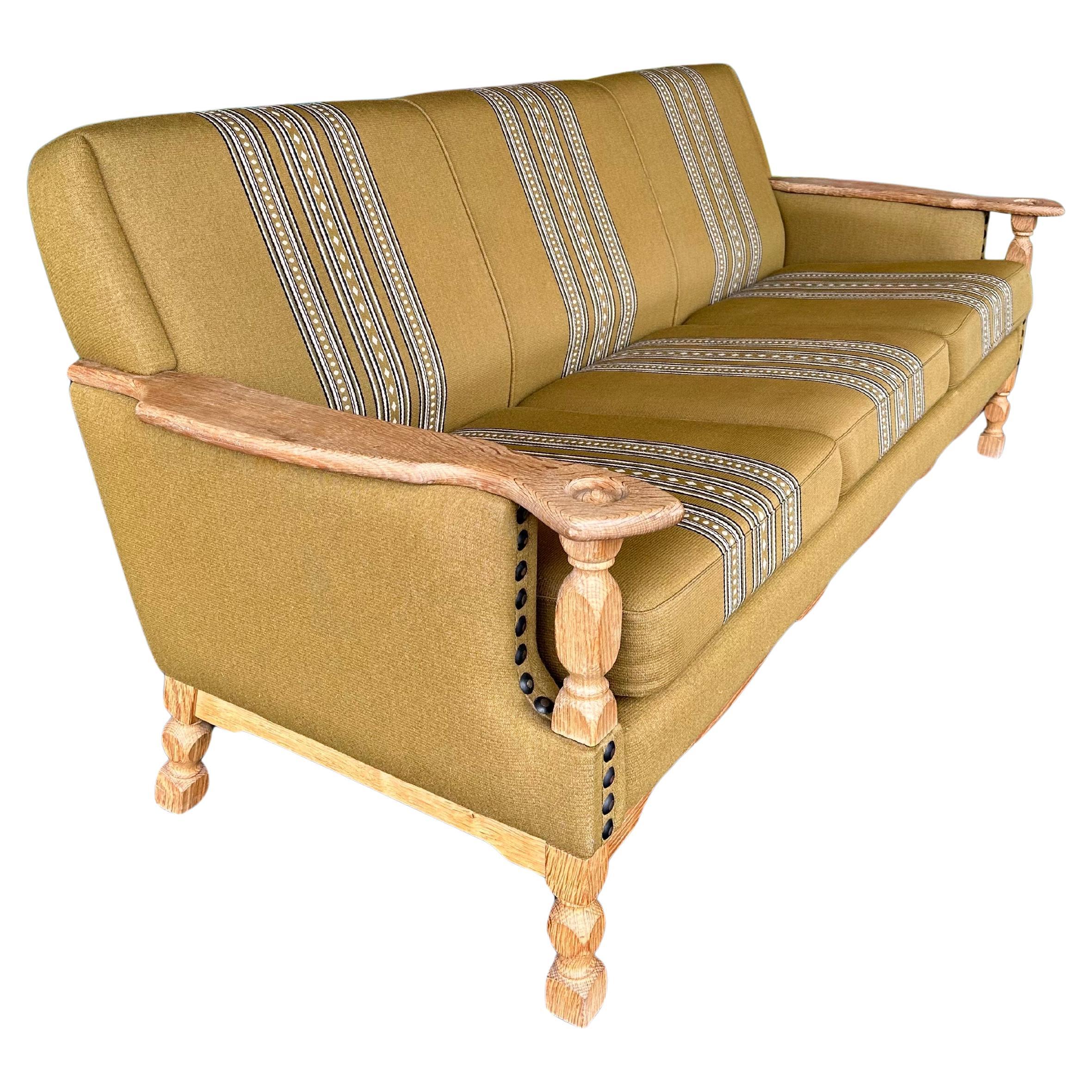 Vintage 1970’s Danish Brutalist Oak 3 seat sofa attributed to Henning Kjaernulf. Quarter sawn White oak carved arms and legs, in traditional Danish Olmer striped green and cream wool upholstery. Good original vintage condition, typical minor age