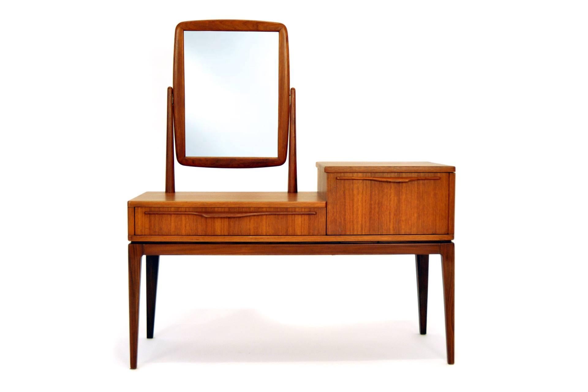 The dressing table was manufactured by Ameublement NF Meuble 212 in France in 1960#s. It is made of teak. The item has one drawer and an case which can be opend and used like storage for cosmetics etc.
 
