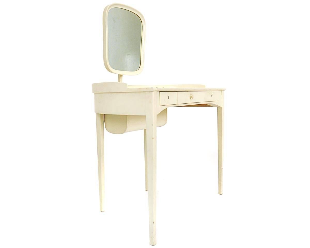 This dressing table was designed by Carl Malmsten in 1962. The manufacturer is Bodafors. It is made of lacquered wood. It has three drawers and one case on the table top. It is possible to adjust the mirror.