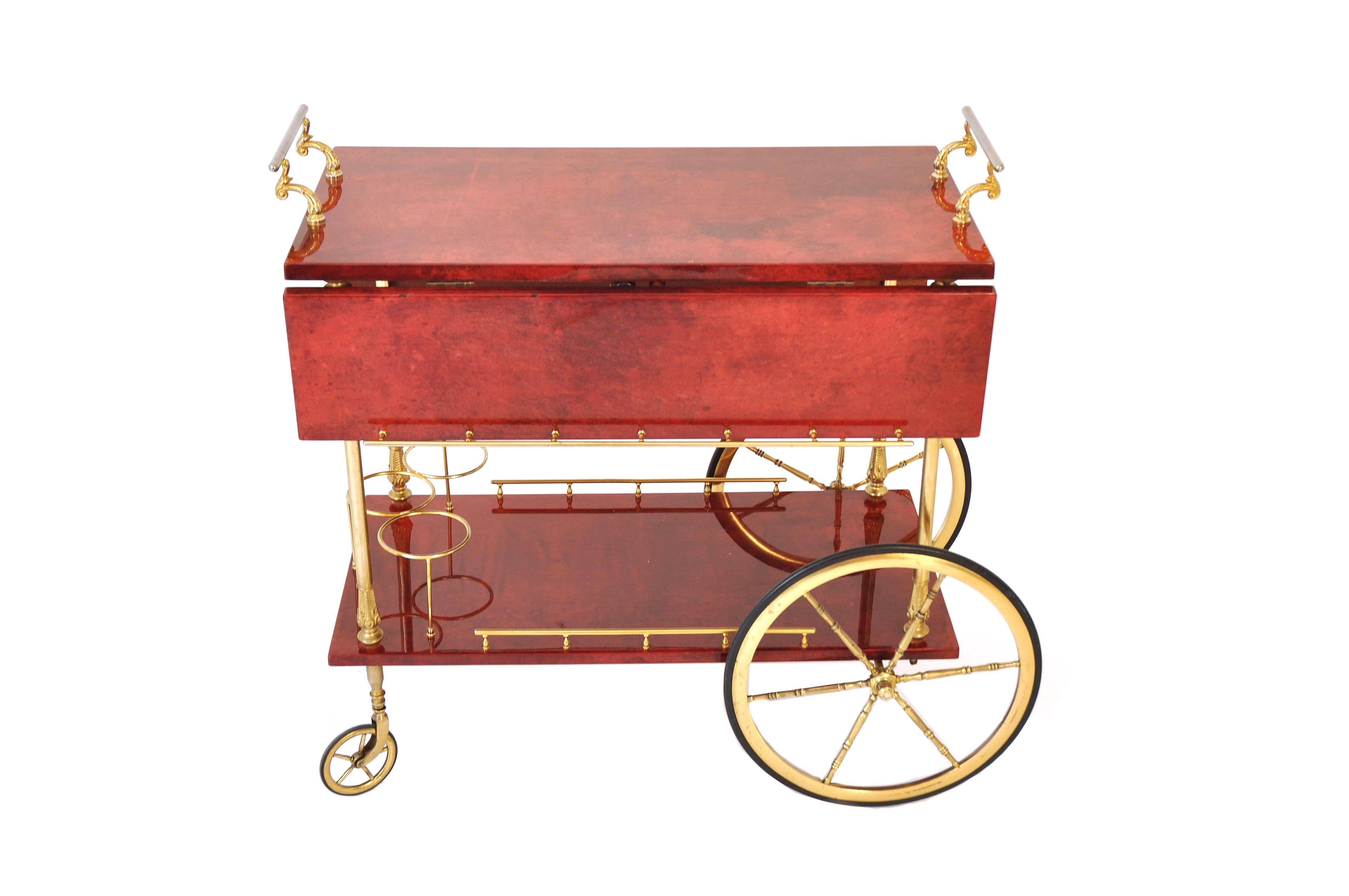 This serving cart was manufactured in Italy by Aldo Tura in 1950s. It is covered with goat skin in red and the details are made of lacquered metal.