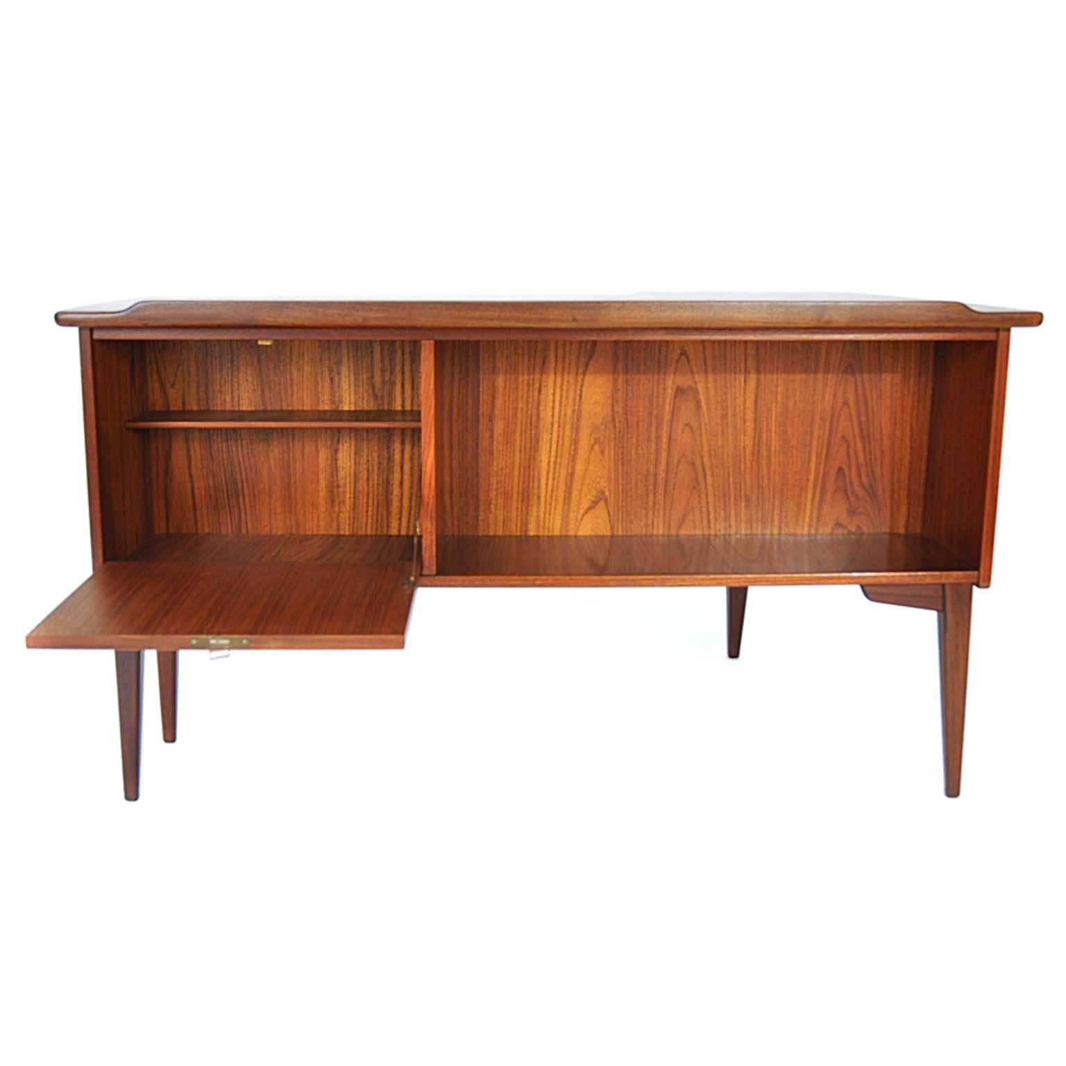 The desk was designed by Gunner Nielsen Tibergaard between 1950-1960 (Denmark). The piece is made of teak. There are three drawers, one of them is lockable. On the backside there is also a lockable case.