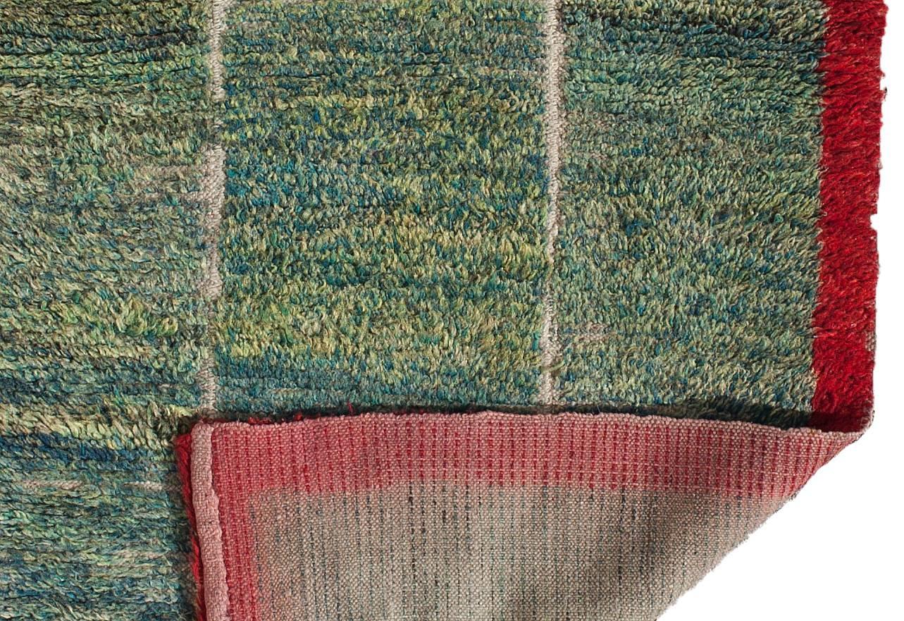 This minimalist yet powerful nomadic weaving is reminiscent of lush green pastures placed in a red frame.

The variety of shades of blue-green in the central field is simply striking. It leaves one to wonder if the weaver intended the strong