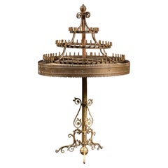 Mesa con candelabro antiguo de latón de varios niveles sobre un soporte ornamentado