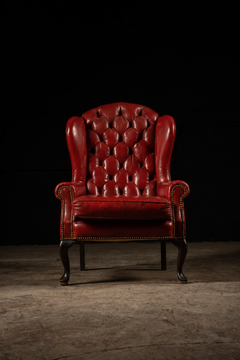 Ensemble d'un fauteuil et d'un pouf anciens en cuir capitonné