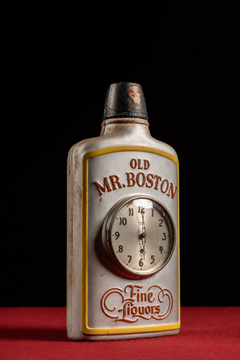 Orologio pubblicitario con bottiglia figurativa "Old Mr. Boston" degli anni '40, realizzato da Gilbert