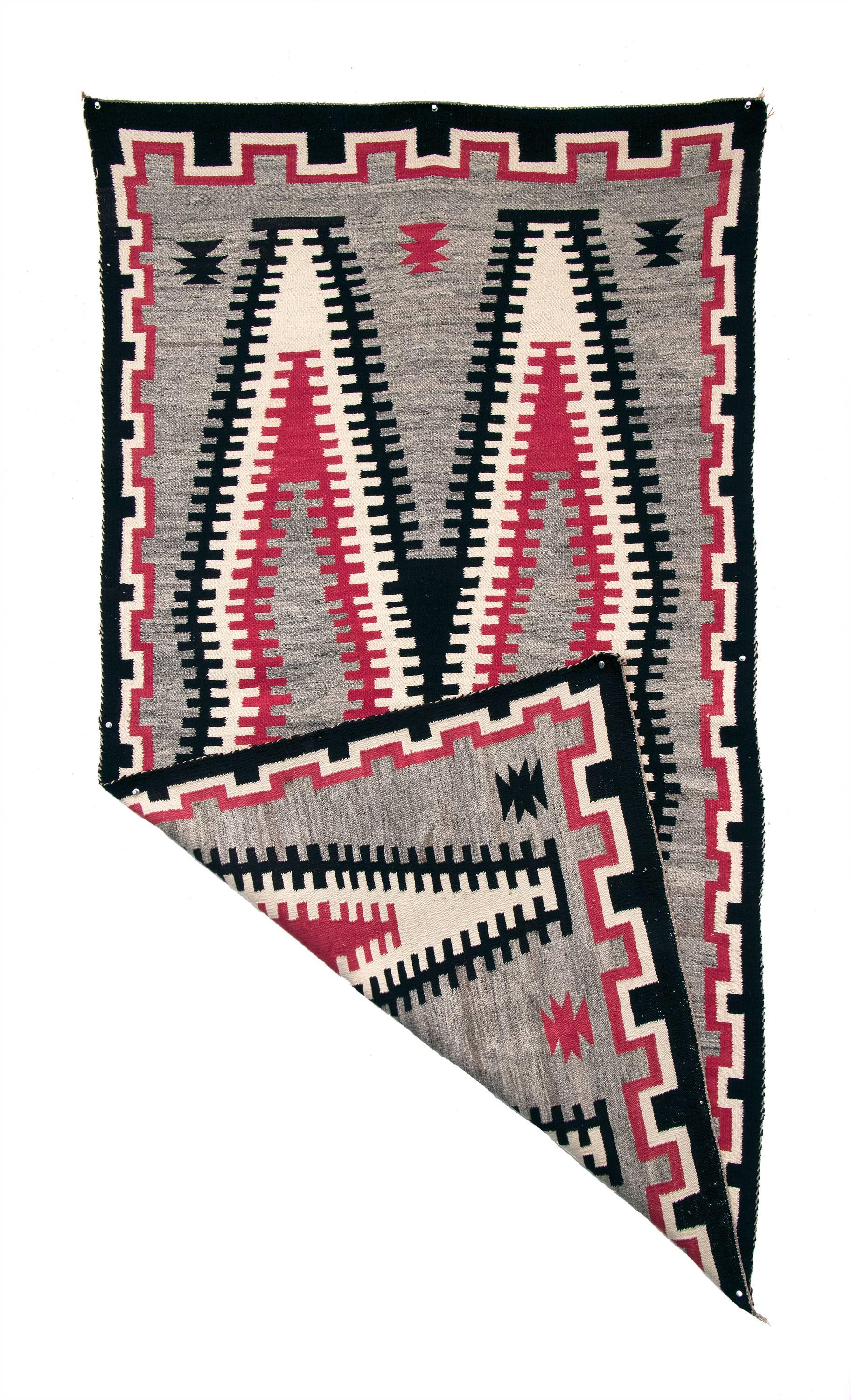 Navajo rug circa 1930. Finely woven from native handspun wool in natural fleece colors of black, ivory and gray with aniline dyed red. Design elements include a stepped border and serrated double diamond center with a grey field.

This textile is