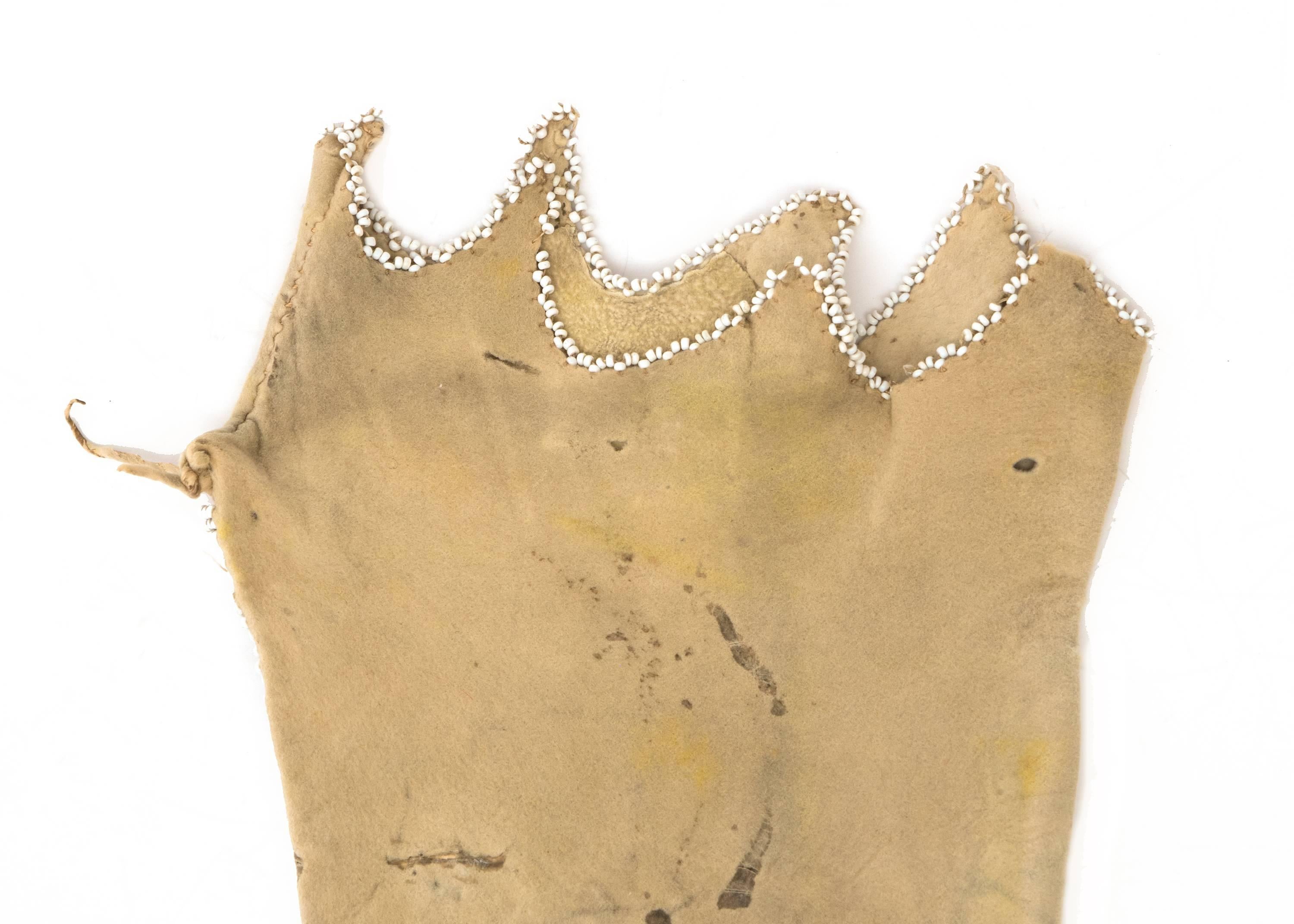 An antique Pipe Bag (Tobacco Bag).  Constructed of native tanned hide and rubbed with yellow ochre.  Design consists of stylized tepee motifs in green, blue, yellow, red and white trade beads.

The Arapaho, members of the Plains Indian culture