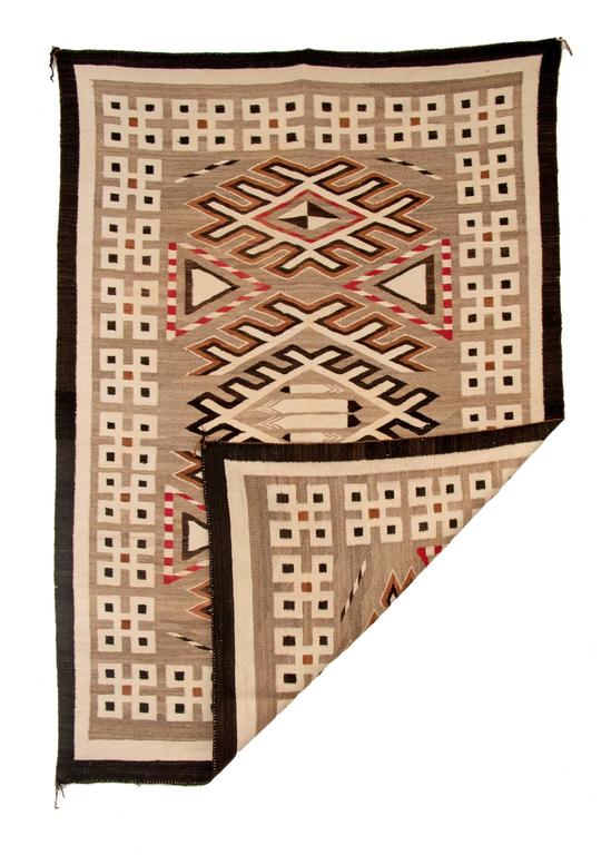 Vintage Navajo rug with a pictorial design from the Trading Post era rug woven of native hand-spun wool in natural fleece colors of ivory, brown and black with aniline red, circa 1900-1925.  Central design elements include of three stylized diamonds