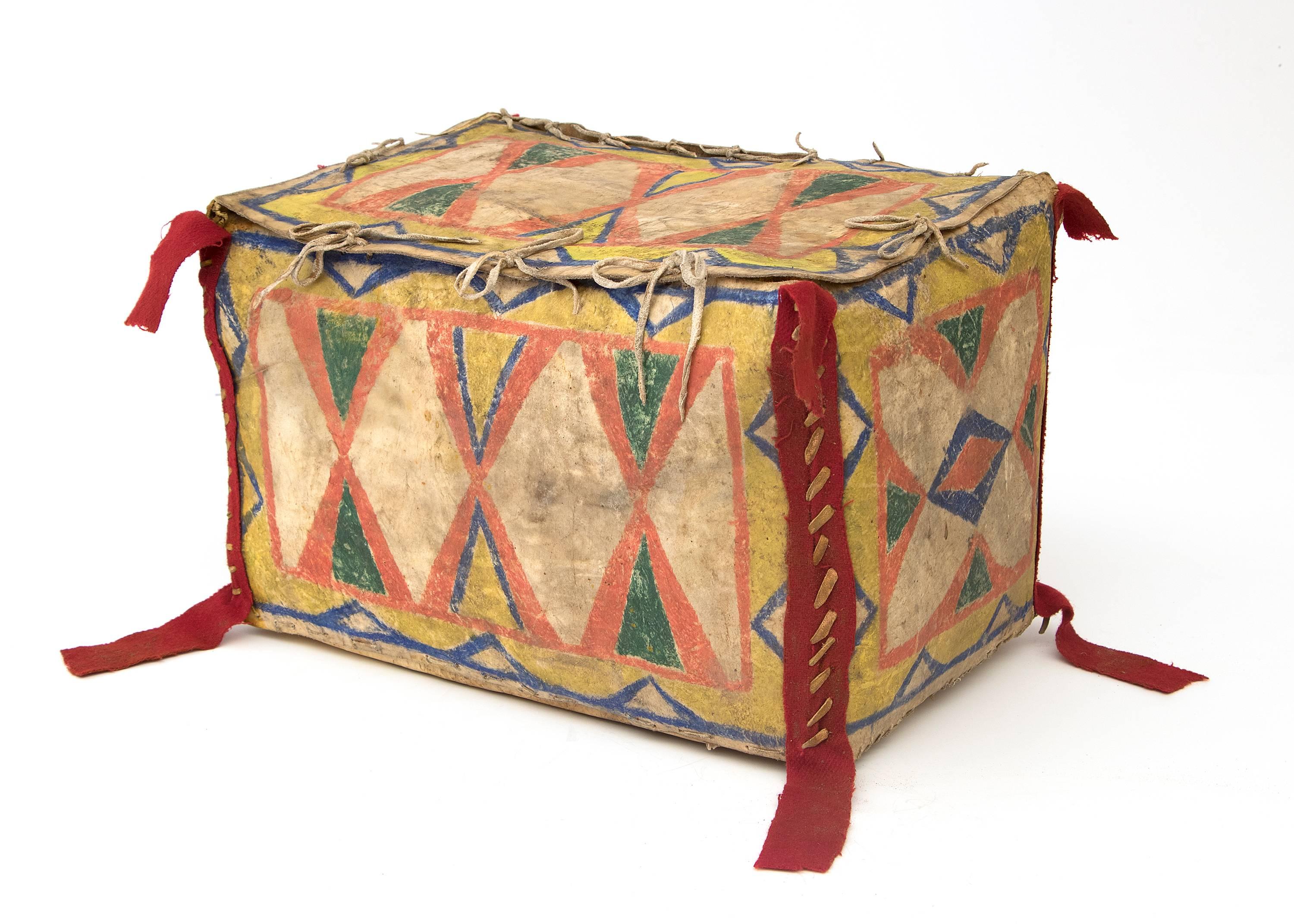 Antike Sioux (Indianer) Parfleche in Kastenform aus Rohleder, die mit natürlichen Pigmenten und rotem Handelsstoff aufwendig mit einem abstrakten Muster aus Sanduhr und geometrischen Motiven bemalt ist.

Zu der Zeit, als diese Karte erstellt wurde,