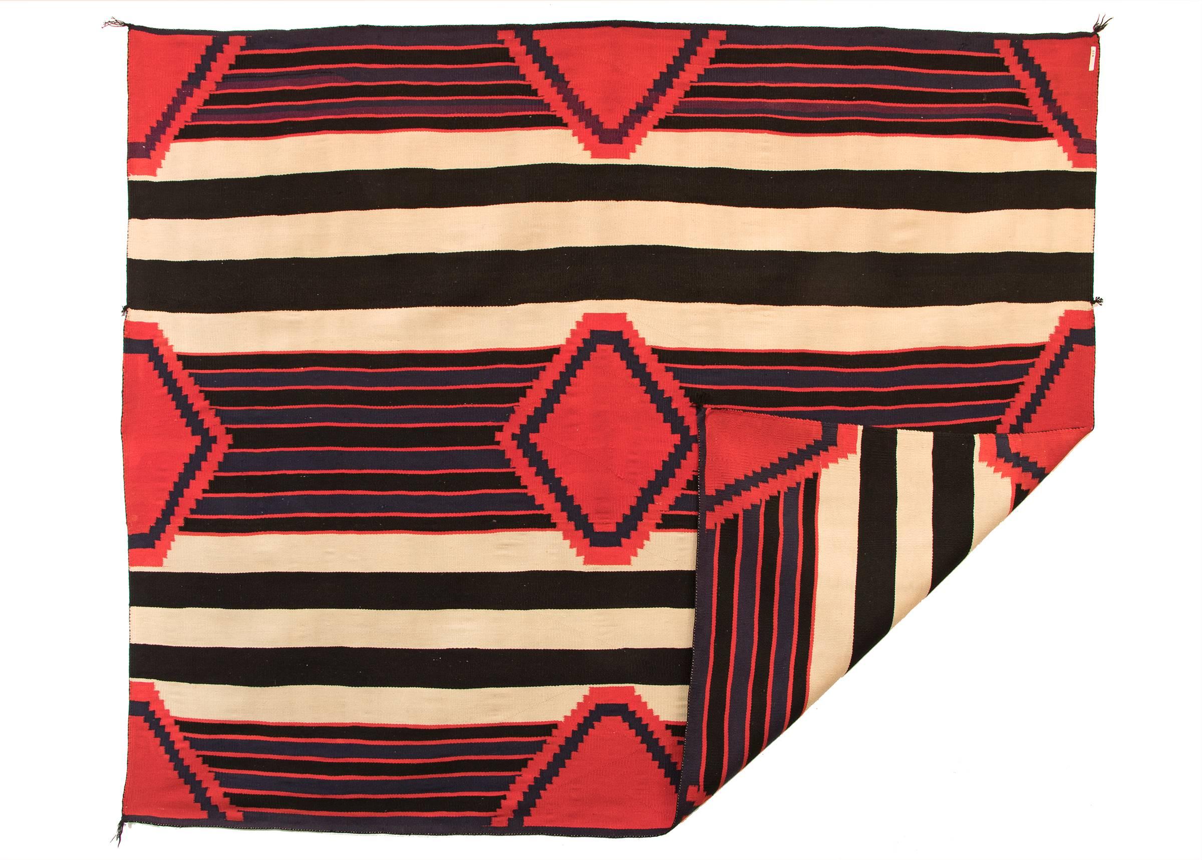 A Navajo chiefs wearing blanket in a traditional third phase design with a nine-point diamond pattern. Woven of four-ply Germantown wool.

Expedited and international shipping is available; please contact us for an estimate.