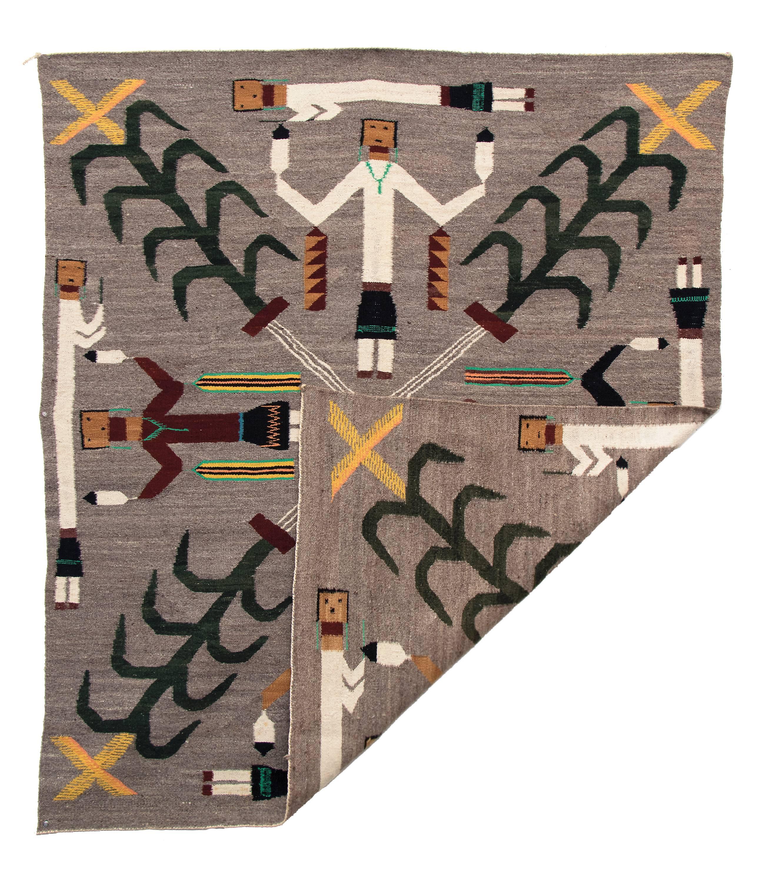 A pictorial weaving with a unique composition it likely depicts a quadrant from a sand painting. Depicted are eight Yei (Yeibichai) figures and four sacred corn plants.

This textile is well suited for use as an area rug, wall hanging or furniture