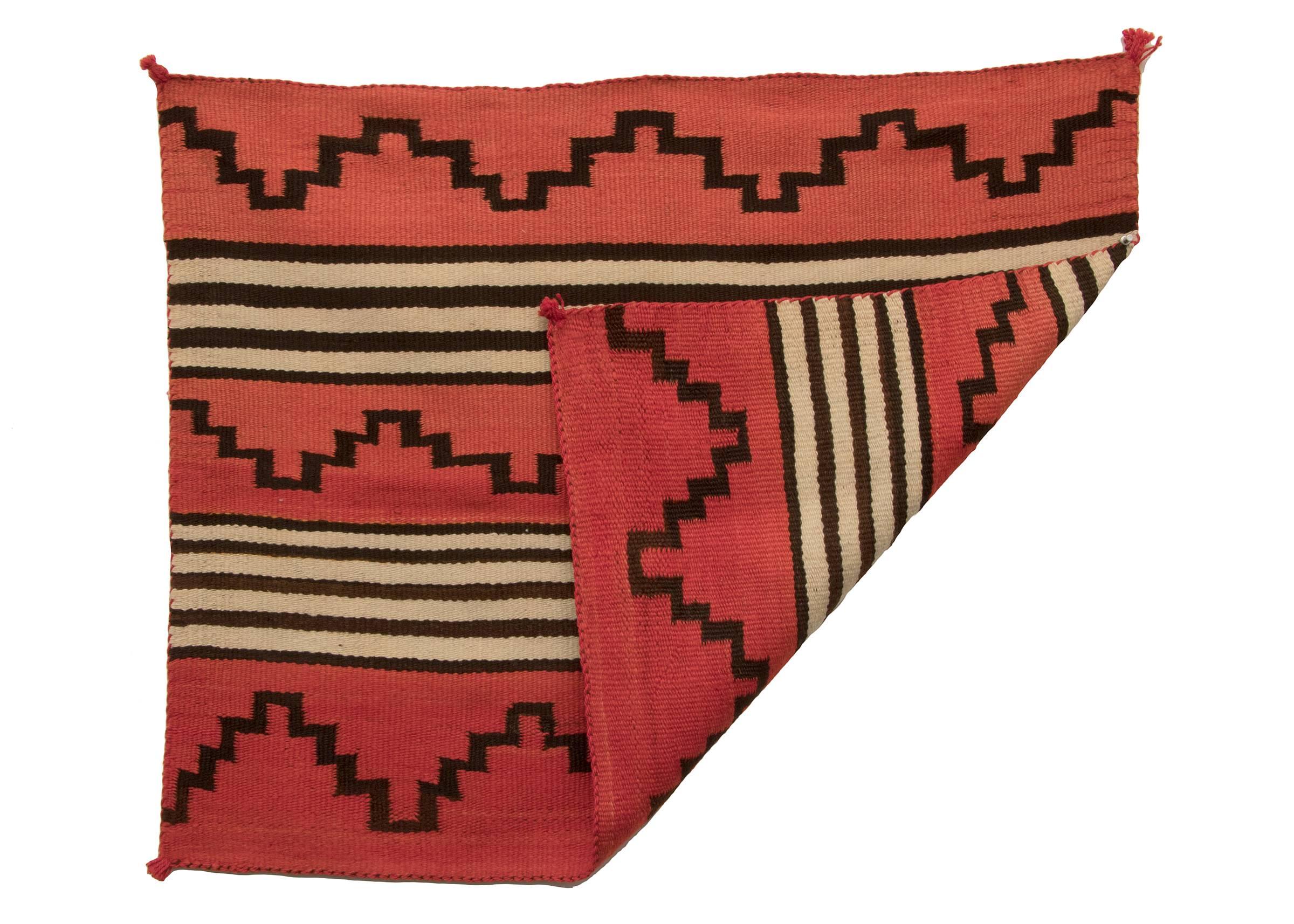 A child-sized variant of a second phase chief's wearing blanket. Woven of native hand-spun wool in natural ivory and brown fleece with aniline-dyed red.

Expedited and international shipping is available; please contact us for an estimate.